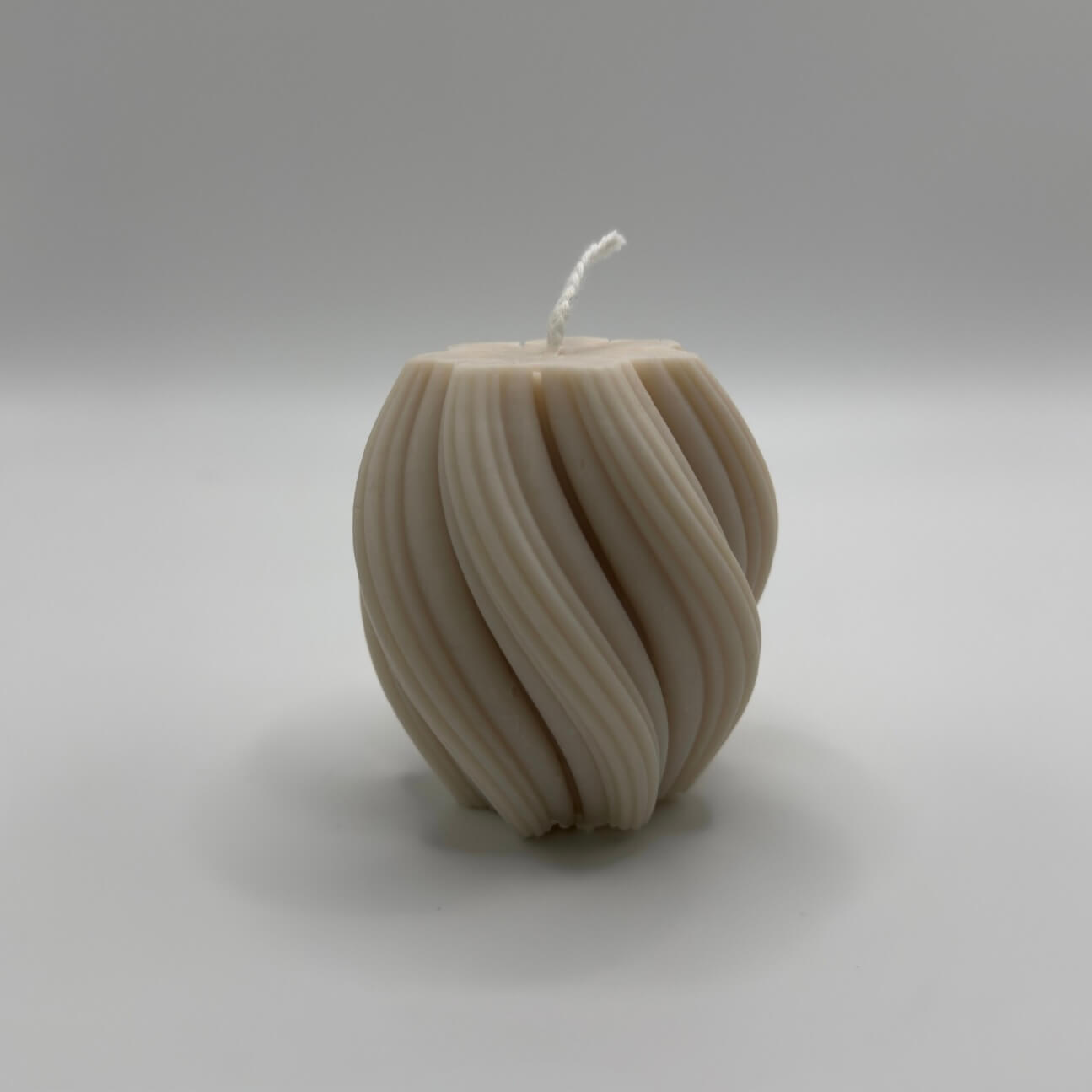 Die „Spiral Glow“ Kerze in Beige, gefertigt aus umweltfreundlichem Sojawachs, kombiniert modernes Twist-Design mit warmem, beruhigendem Licht für besondere Wohlfühlmomente.