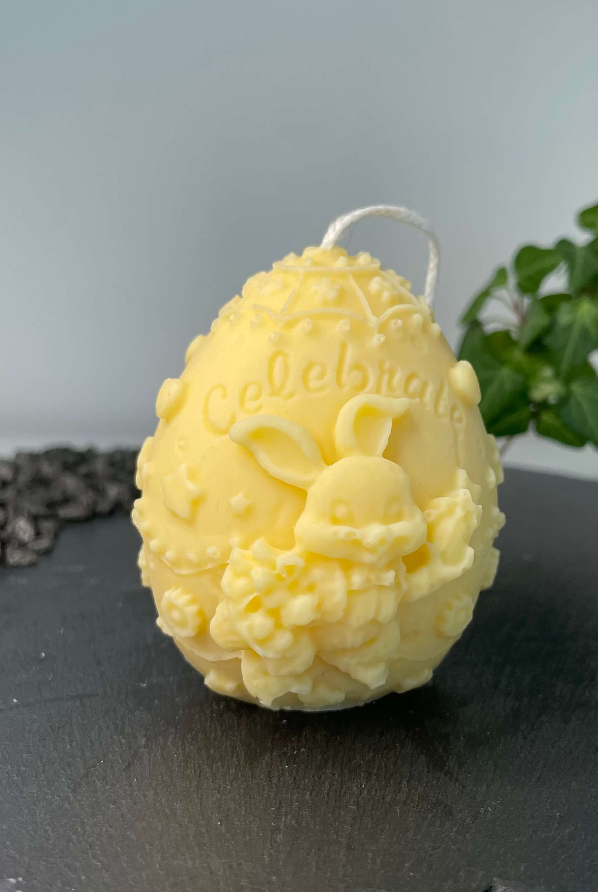 Auf diesem Bild sieht man unsere Bunny Celebration Egg Kerze. Sie ist handgemacht aus Sojawachs. Zudem ist sie auch nachhaltig, vegan und umweltfreundlich. In gelb.