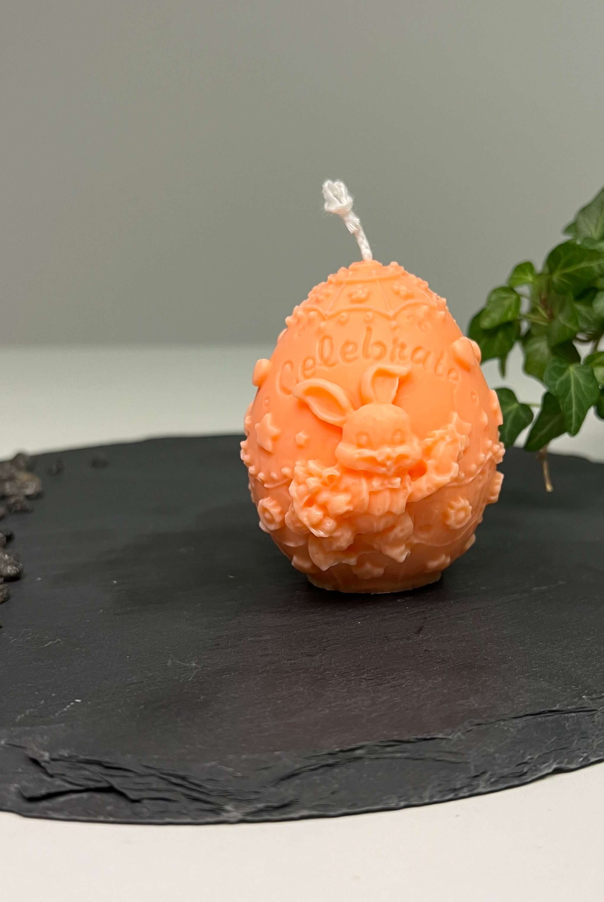 Auf diesem Bild sieht man unsere Bunny Celebration Egg Kerze. Sie ist handgemacht aus Sojawachs. Zudem ist sie auch nachhaltig, vegan und umweltfreundlich. In orange.