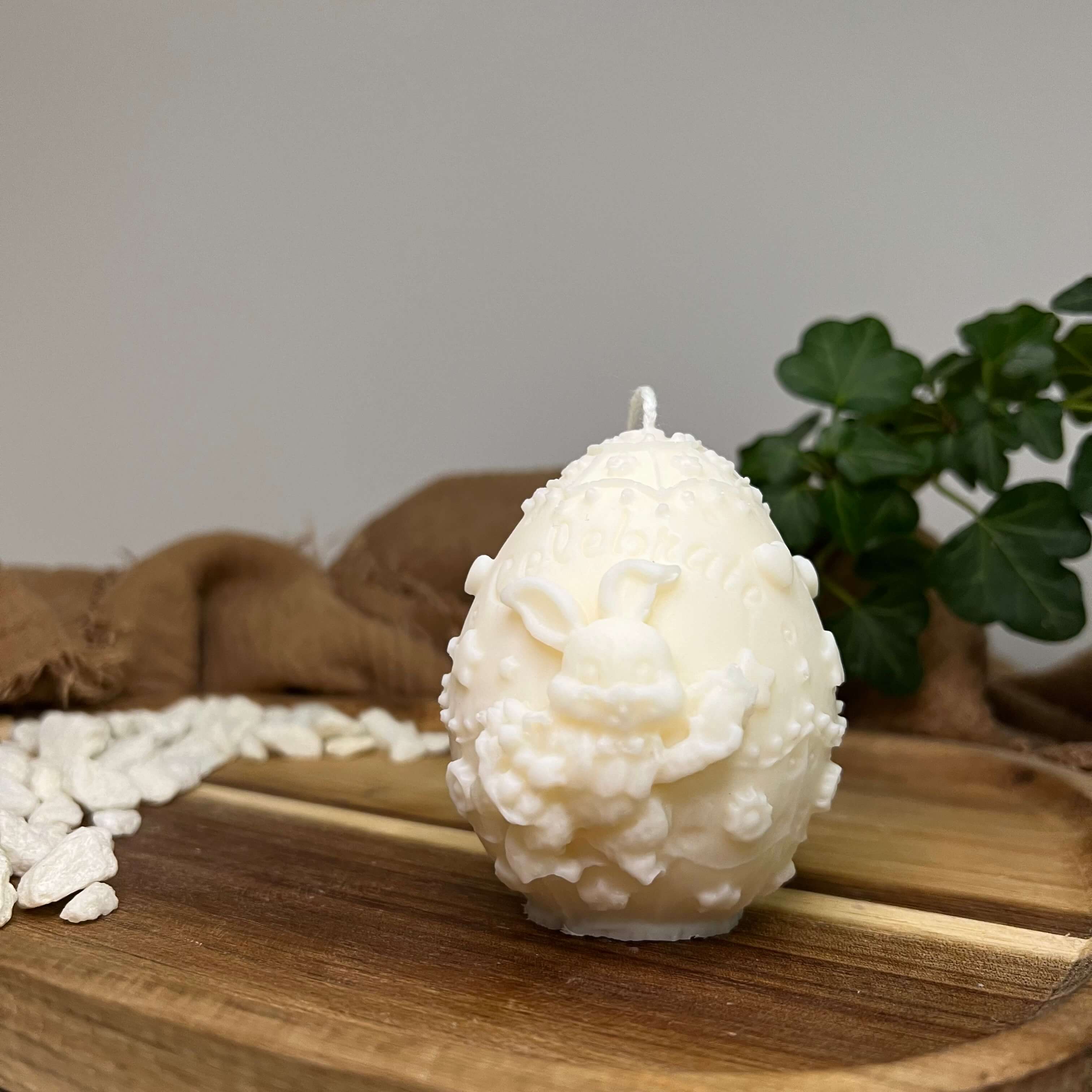 Hier sieht man unsere Bunny Celebration Egg Kerze. Mit ihrem Osterei und Hasen Design ist sie perfekt als Dekoration geeignet. Sie ist ästhetisch, stilvoll und elegant. In weiß.