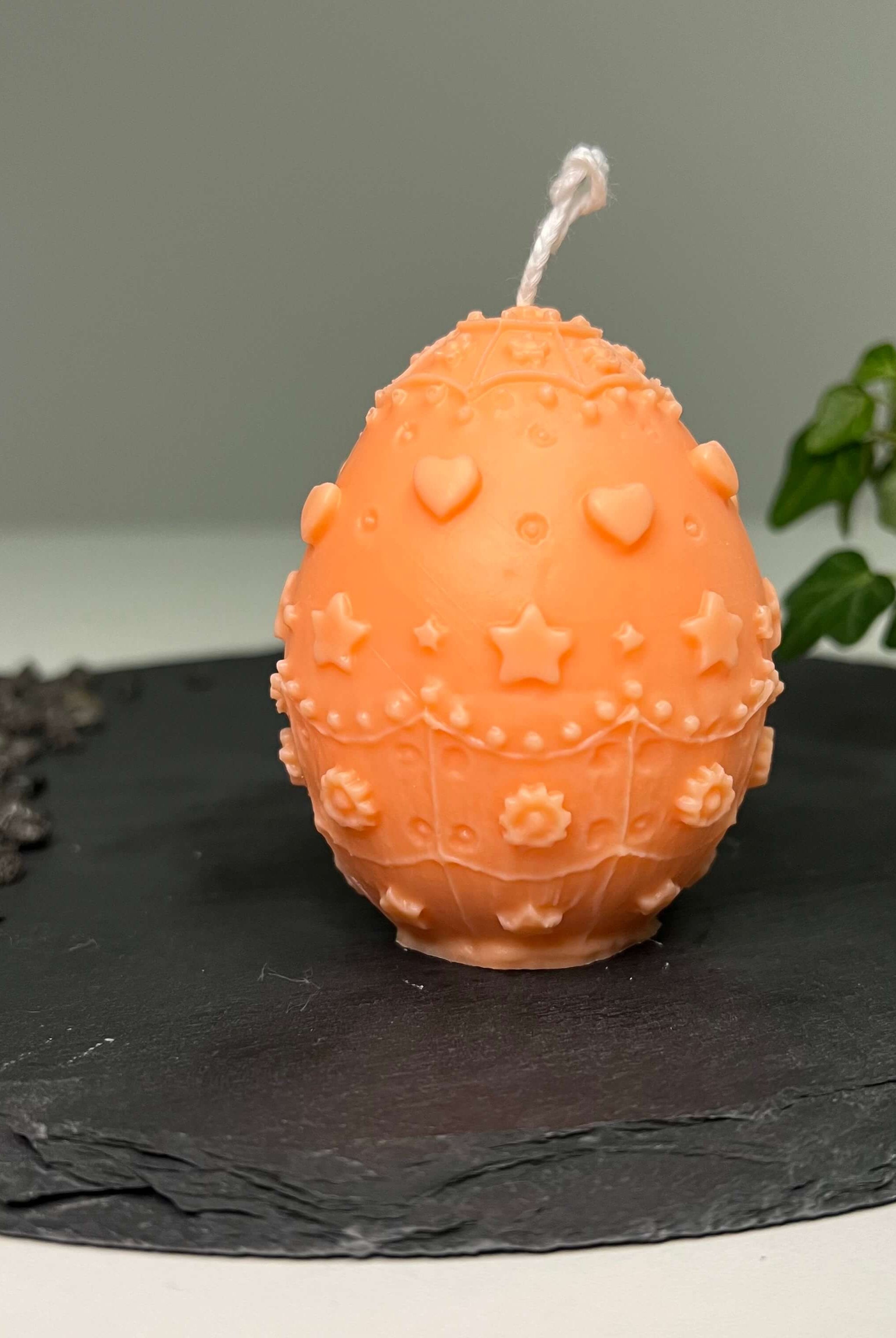 Diese Osterkerze namens Bunny Celebration Egg ist einzigartig und wunderschön. Sie passt als Osterdekoration in jedes Zuhause. In orange.