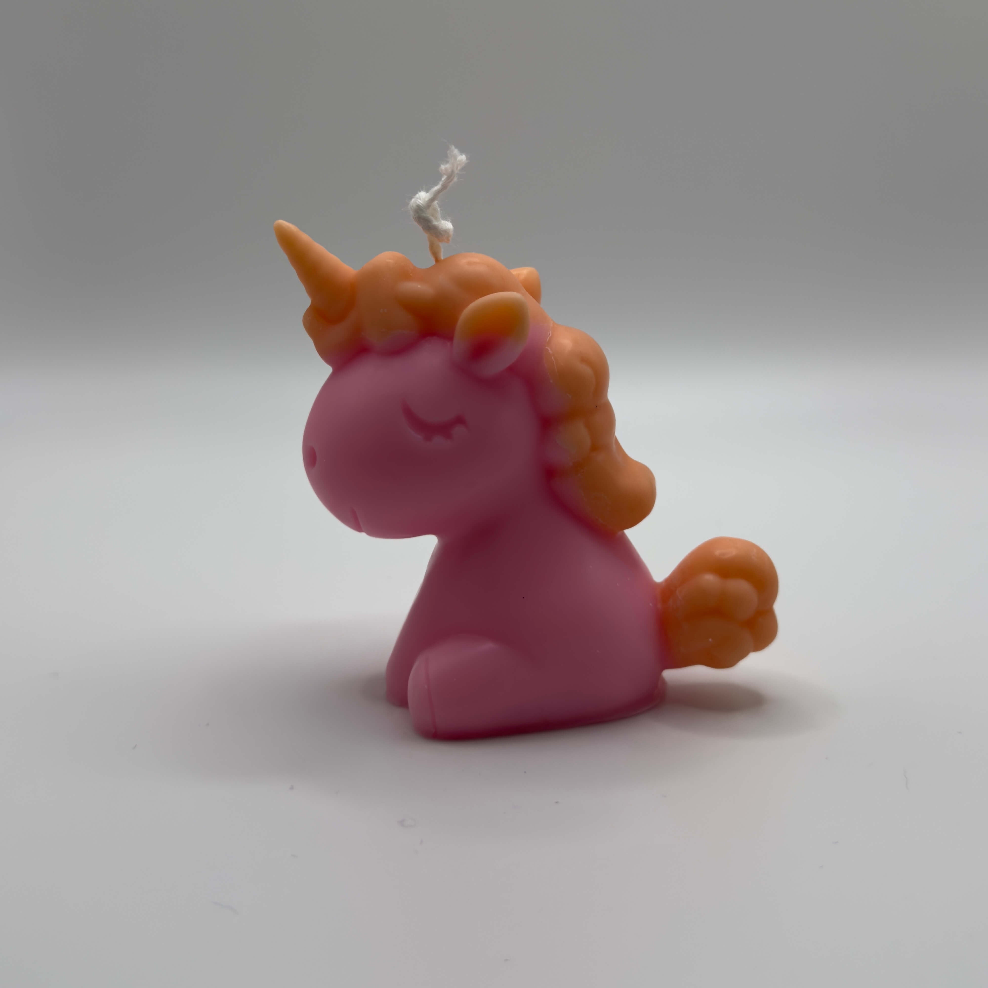 Detailreich gestaltete Celestial Unicorn Einhornkerze in Pink mit orangen Details aus Sojawachs – handgegossene, vegane Kerze für Kinderzimmer oder als Geschenk.