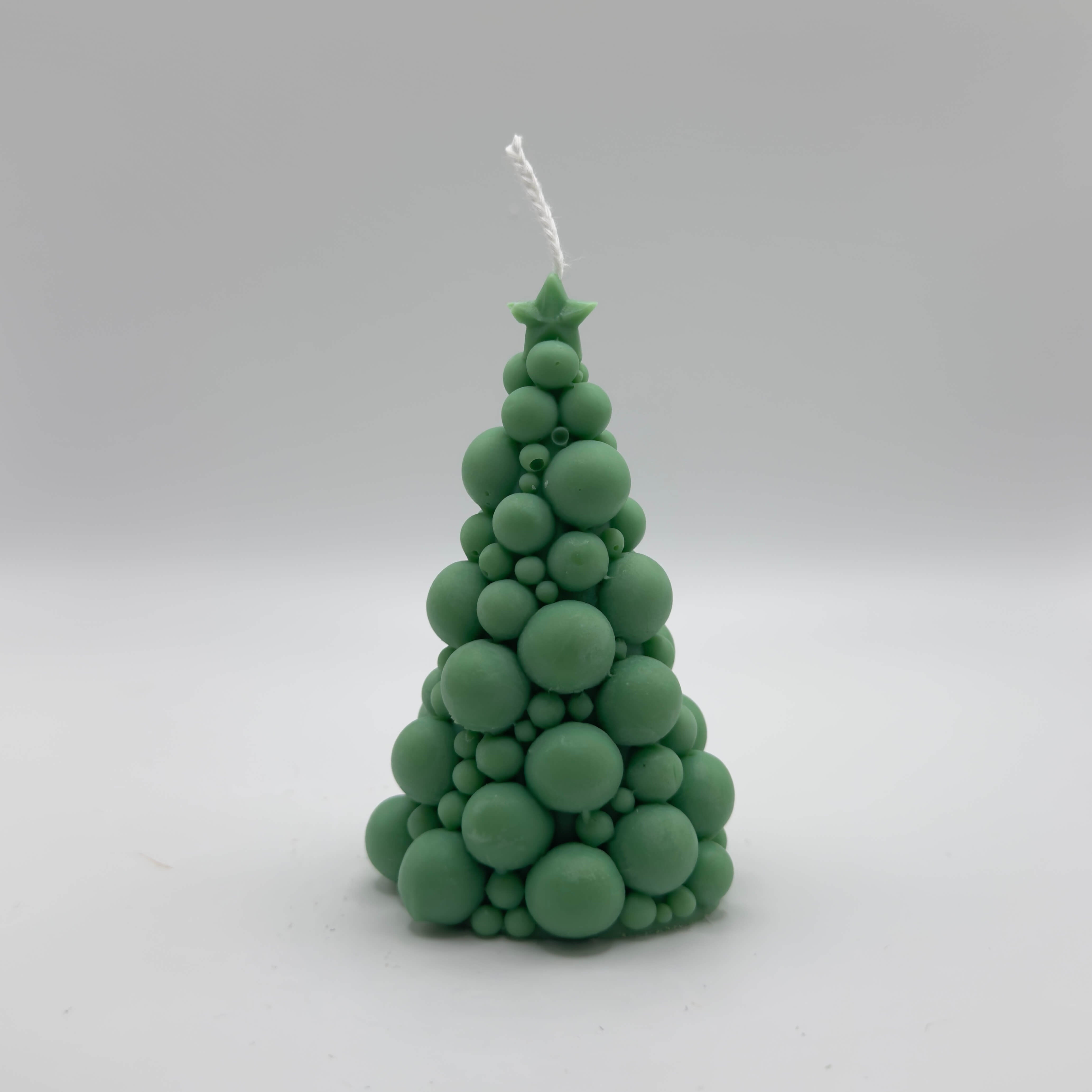 Festliche “Bubbly Christmas Tree Candle” in Dunkelgrün. Handgefertigt aus Sojawachs mit kreativem Bubble-Design und einem Stern an der Spitze, perfekt als Blickfang für die Feiertage.