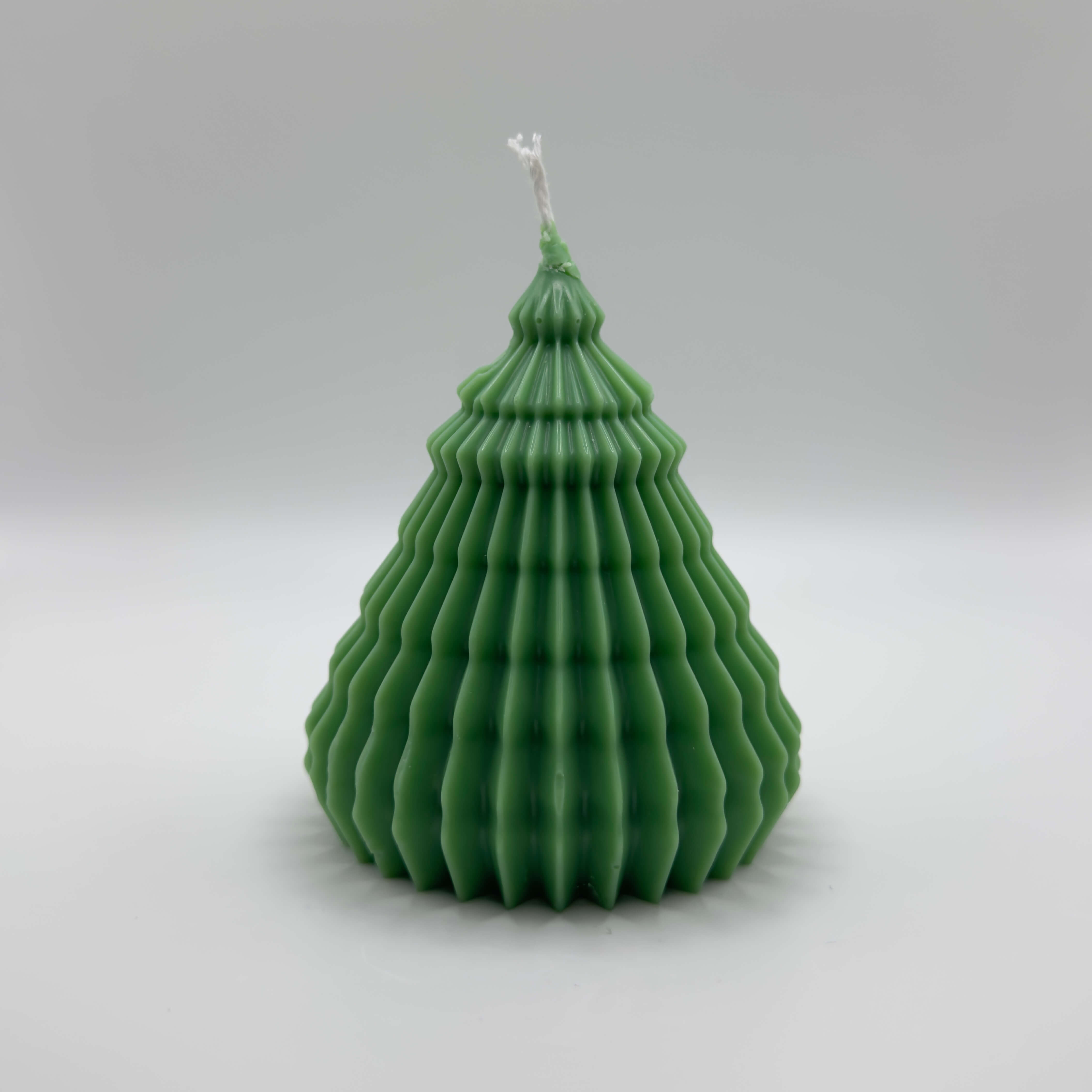 Die “Rippled Tree Candle” in Dunkelgrün mit einem eleganten, gerillten Design. Diese handgefertigte Sojawachs-Kerze vereint modernes Design und festliche Eleganz, perfekt für die Weihnachtsdekoration.