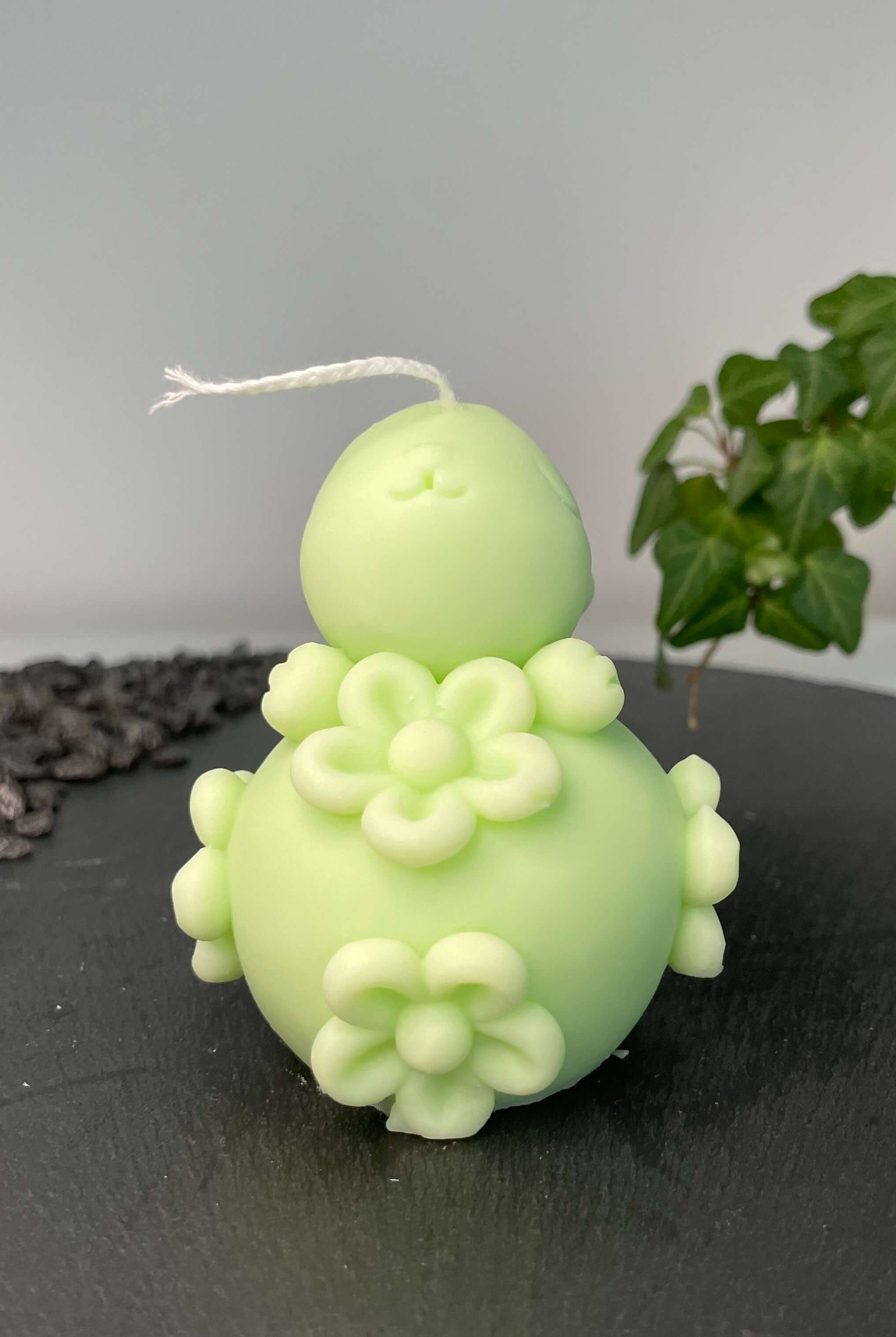 Die Enchanting Rabbit Osterkerze in Hellblau. Sie hat ein Hasendesign und Ostereidesign. In Hellgrün.