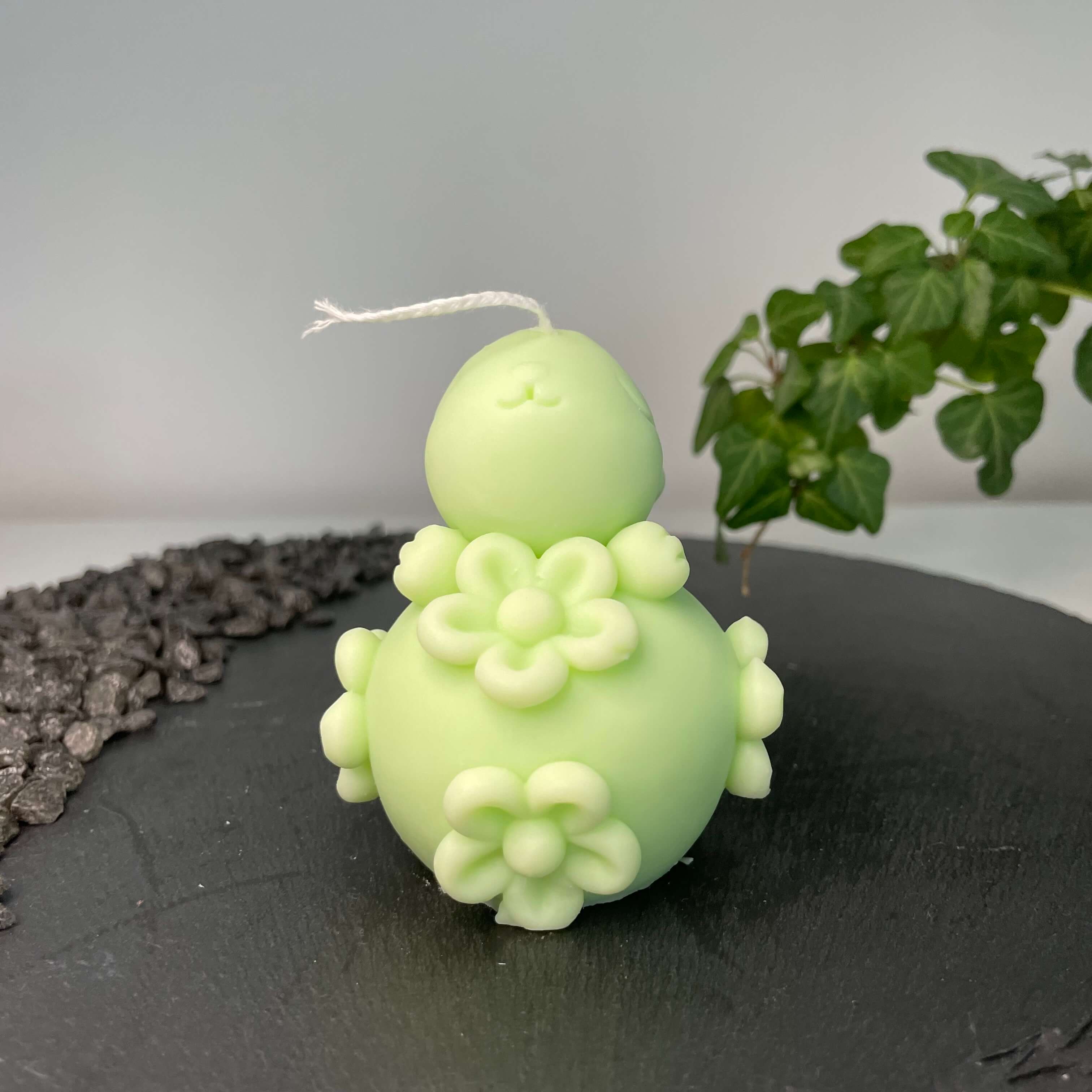 Die Enchanting Rabbit Osterkerze in Hellblau. Sie hat ein Hasendesign und Ostereidesign. In Hellgrün.