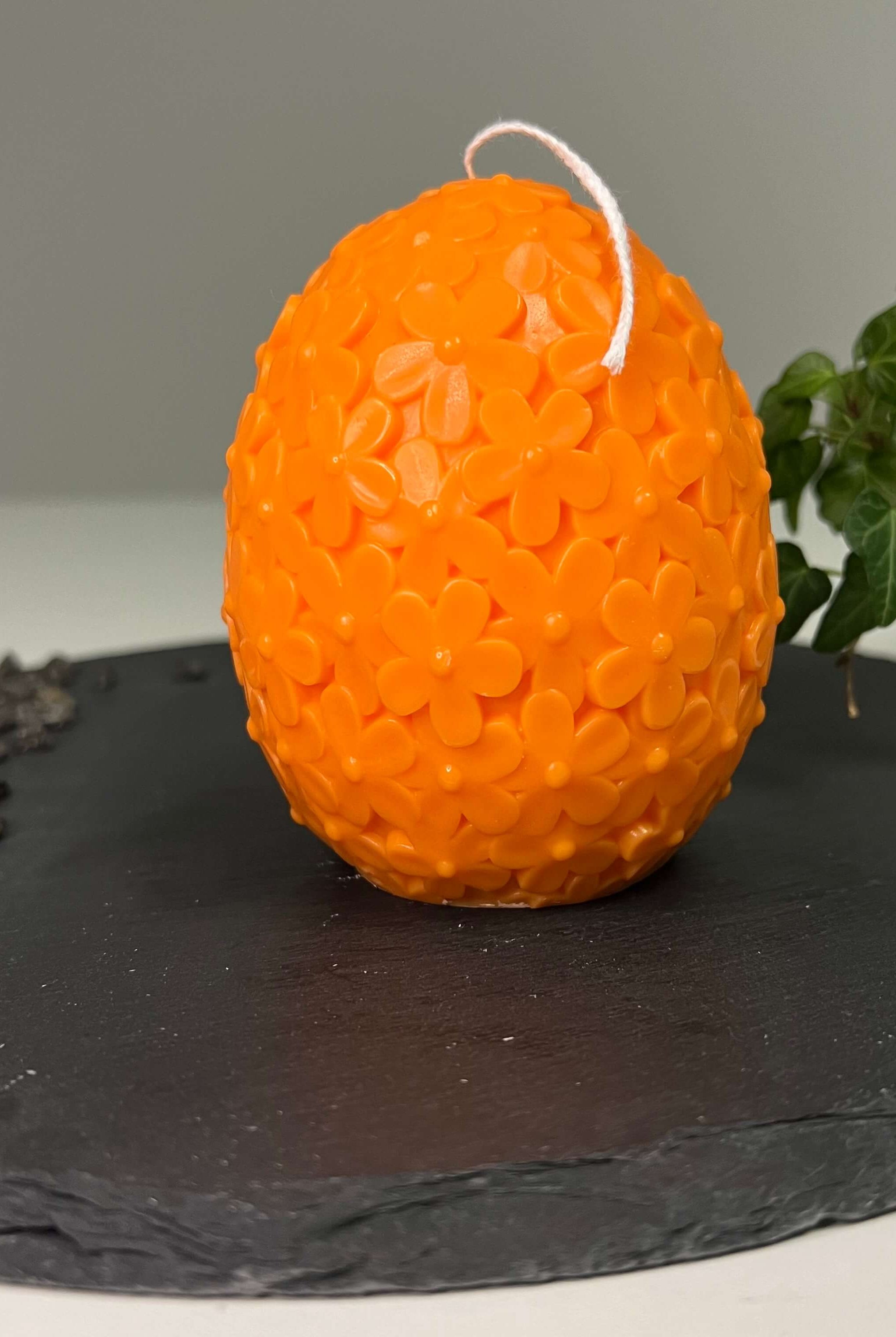 Auf diesem Bild sieht man unsere Floral Easter Egg Brilliance Kerze. Sie ist handgemacht aus Sojawachs. Sie ist nachhaltig, vegan und umweltfreundlich. In orange.