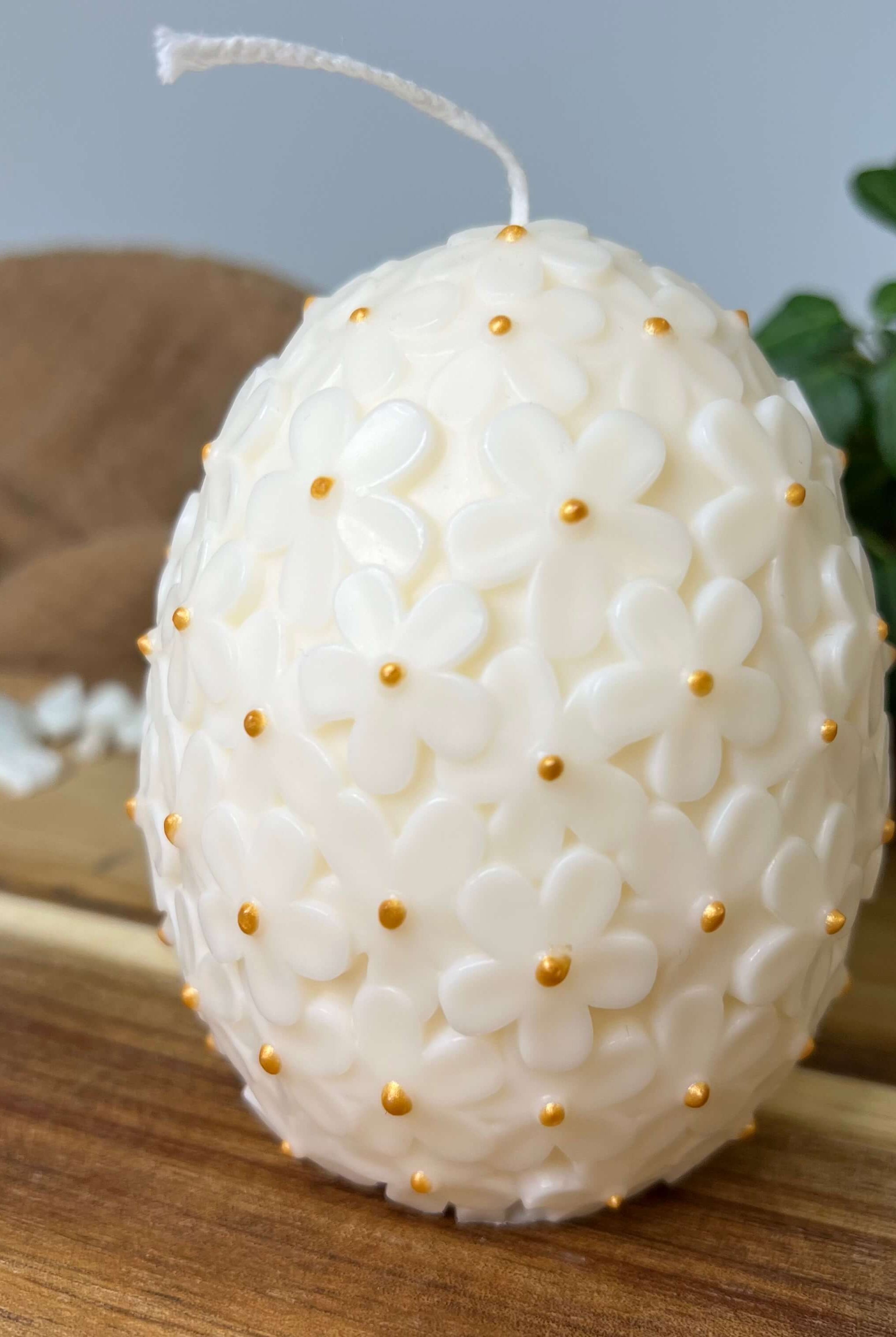 Auf diesem Bild sieht man unsere Floral Easter Egg Brilliance Kerze. Sie ist handgemacht aus Sojawachs. Sie ist nachhaltig, vegan und umweltfreundlich. In Weiß-Gold.