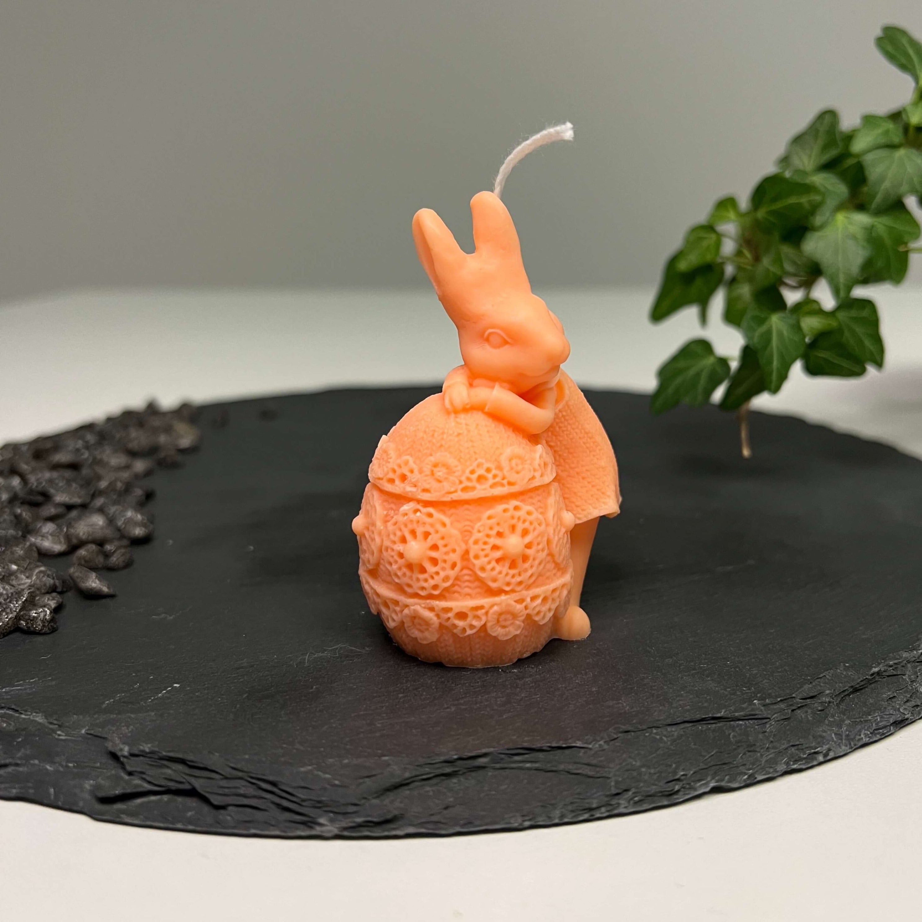 Hier sieht man unsere Fluffy Bunny Nest Egg Kerze. Mit ihrem Osterhasen und Osterei Design ist sie perfekt als Dekoration geeignet. Sie sieht elegant und ästhetisch aus. In orange.