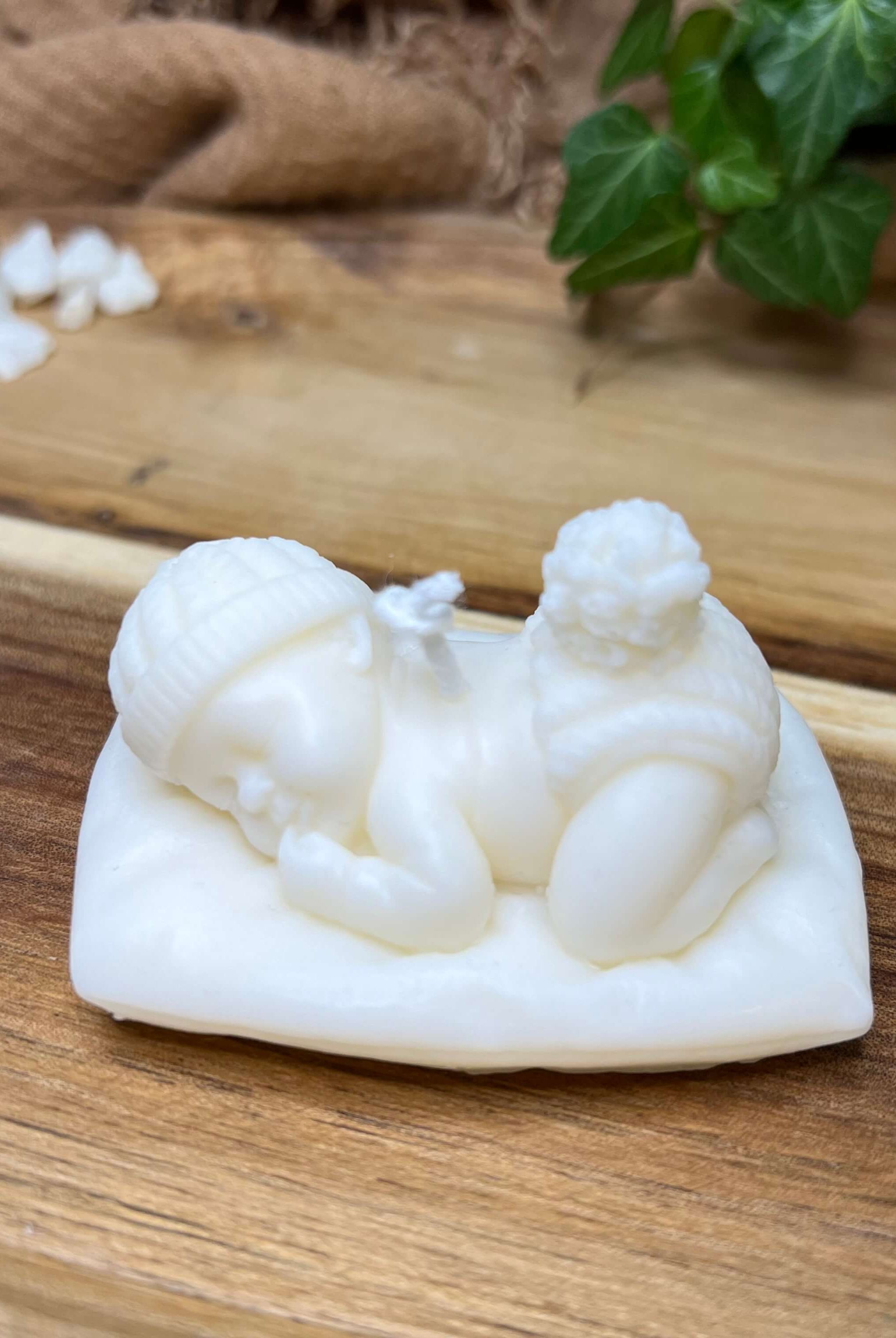 Die handgemachte und vegane Sojawachskerze Heavenly Slumber Baby. Sie zeigt ein schlafendes Baby, liegend auf einem Kissen.