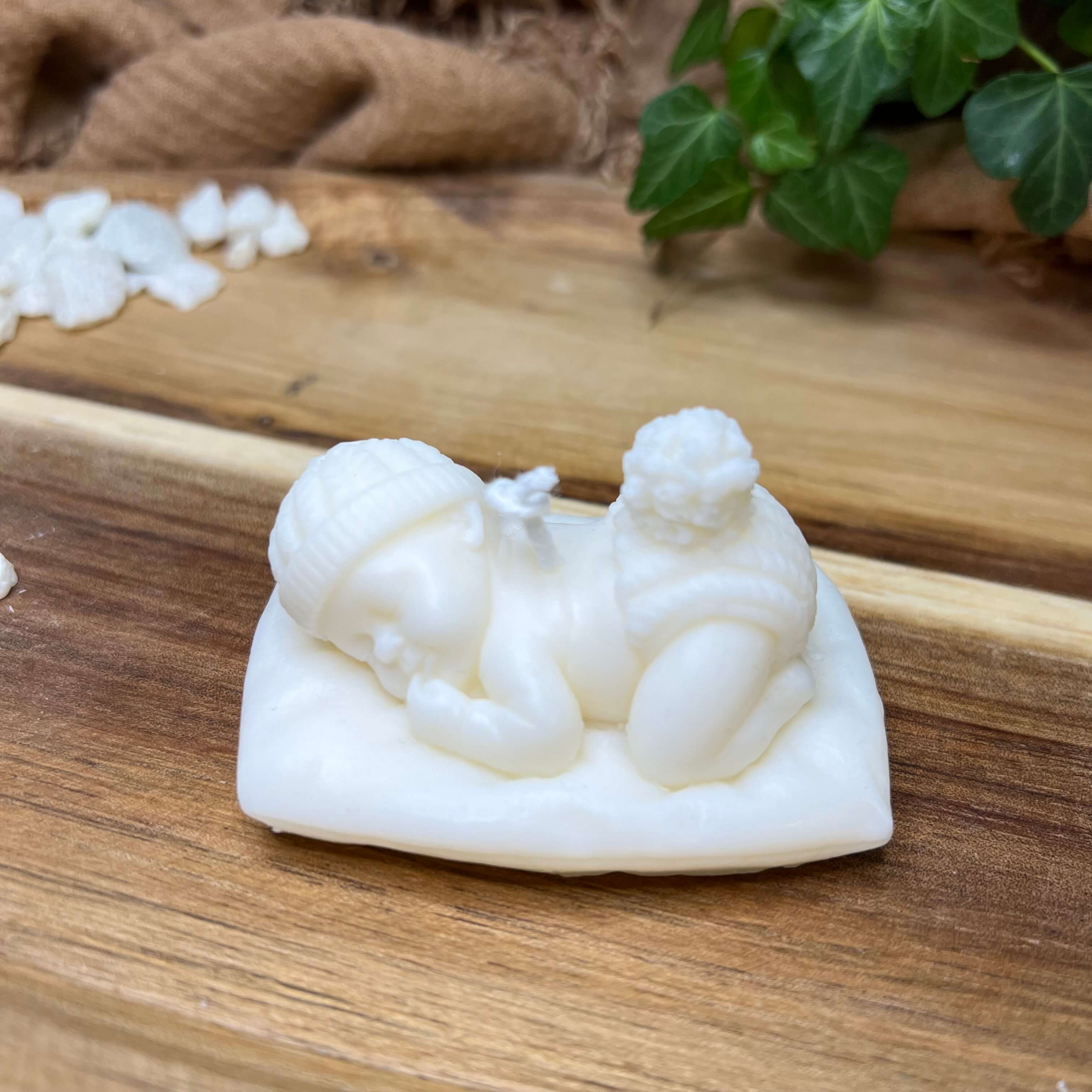 Die handgemachte und vegane Sojawachskerze Heavenly Slumber Baby. Sie zeigt ein schlafendes Baby, liegend auf einem Kissen.