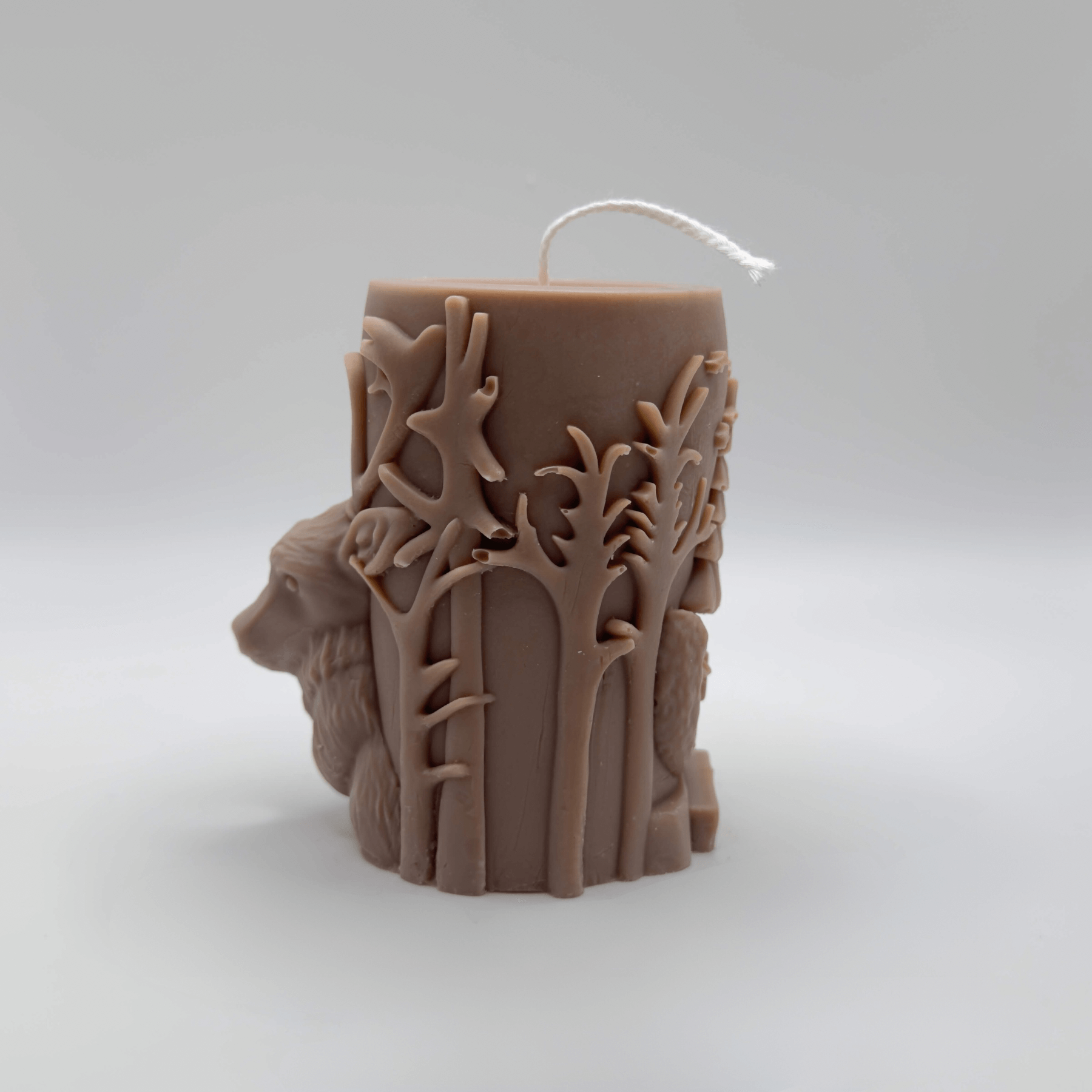 Die handgefertigte “Woodland Majesty” Kerze in Hellbraun kombiniert ein realistisches Baumstamm-Design mit einem 3D-Hirsch und weihnachtlichen Details, um eine warme, festliche Atmosphäre zu schaffen.