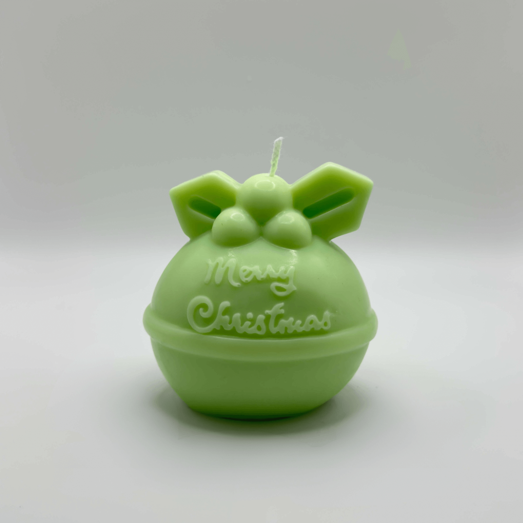 Die „Mistletoe Merry“-Kerze in Hellgrün, geformt wie eine traditionelle Weihnachtskugel, verziert mit einem zarten Mistelzweig und dem Gruß „Merry Christmas“. Diese handgefertigte Sojawachs-Kerze ist ein elegantes und nachhaltiges Highlight für Ihre Weihnachtsdekoration.