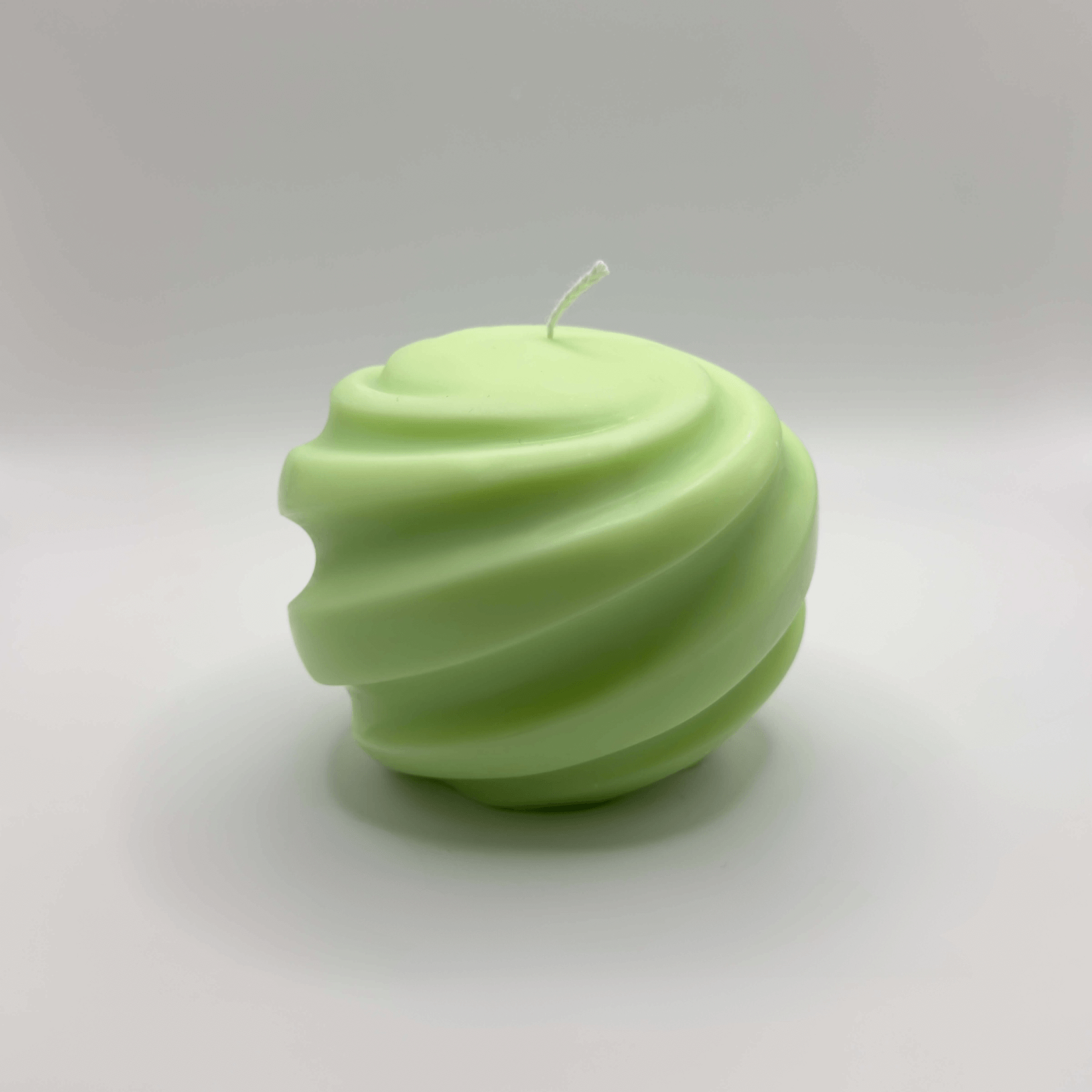 Die handgefertigte „Ribbed Christmas Bauble“ Kerze in Hellgrün kombiniert Nachhaltigkeit und Eleganz durch ihr einzigartiges Spiraldesign und ist ideal für die festliche Dekoration.