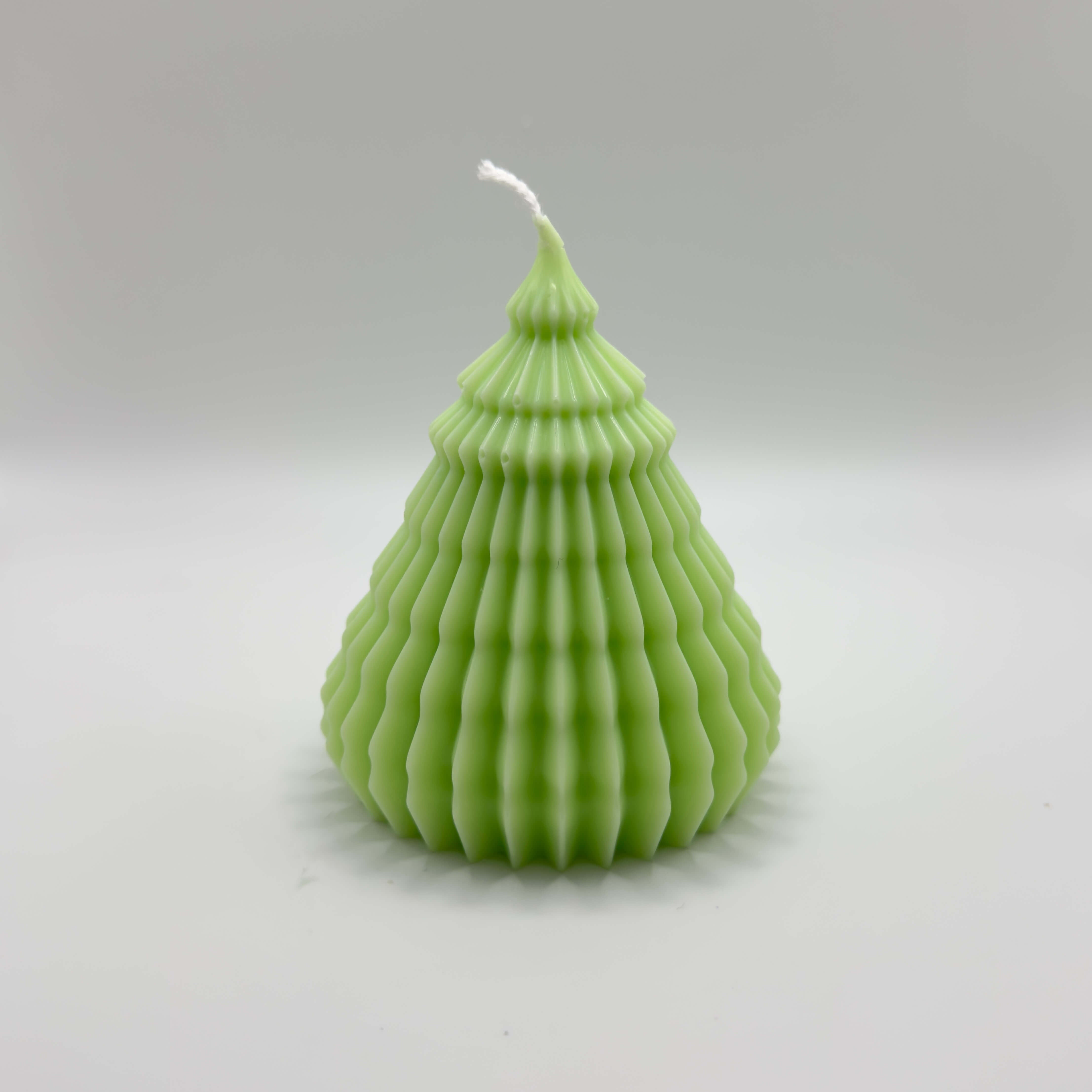 Die “Rippled Tree Candle” in Hellgrün mit einem zeitlosen, wellenartigen Design. Handgefertigt aus natürlichem Sojawachs, sorgt sie für eine moderne und gemütliche Weihnachtsstimmung.