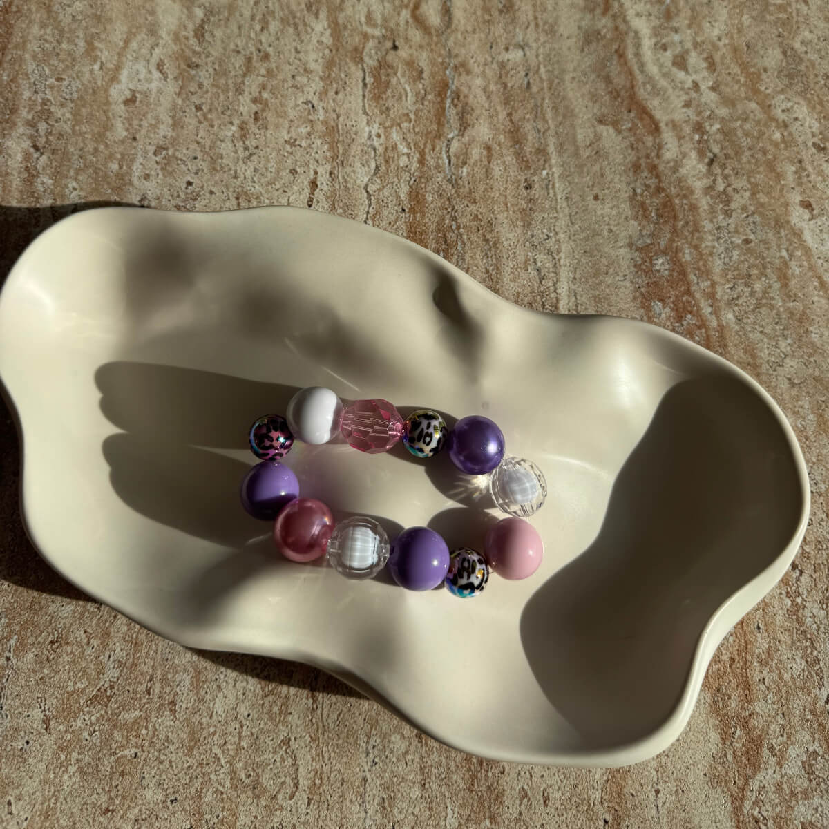 Komplette Ansicht des Pastel Safari Armbands in einer Schale, farbenfrohe Pastell- und Safari-Perlen.