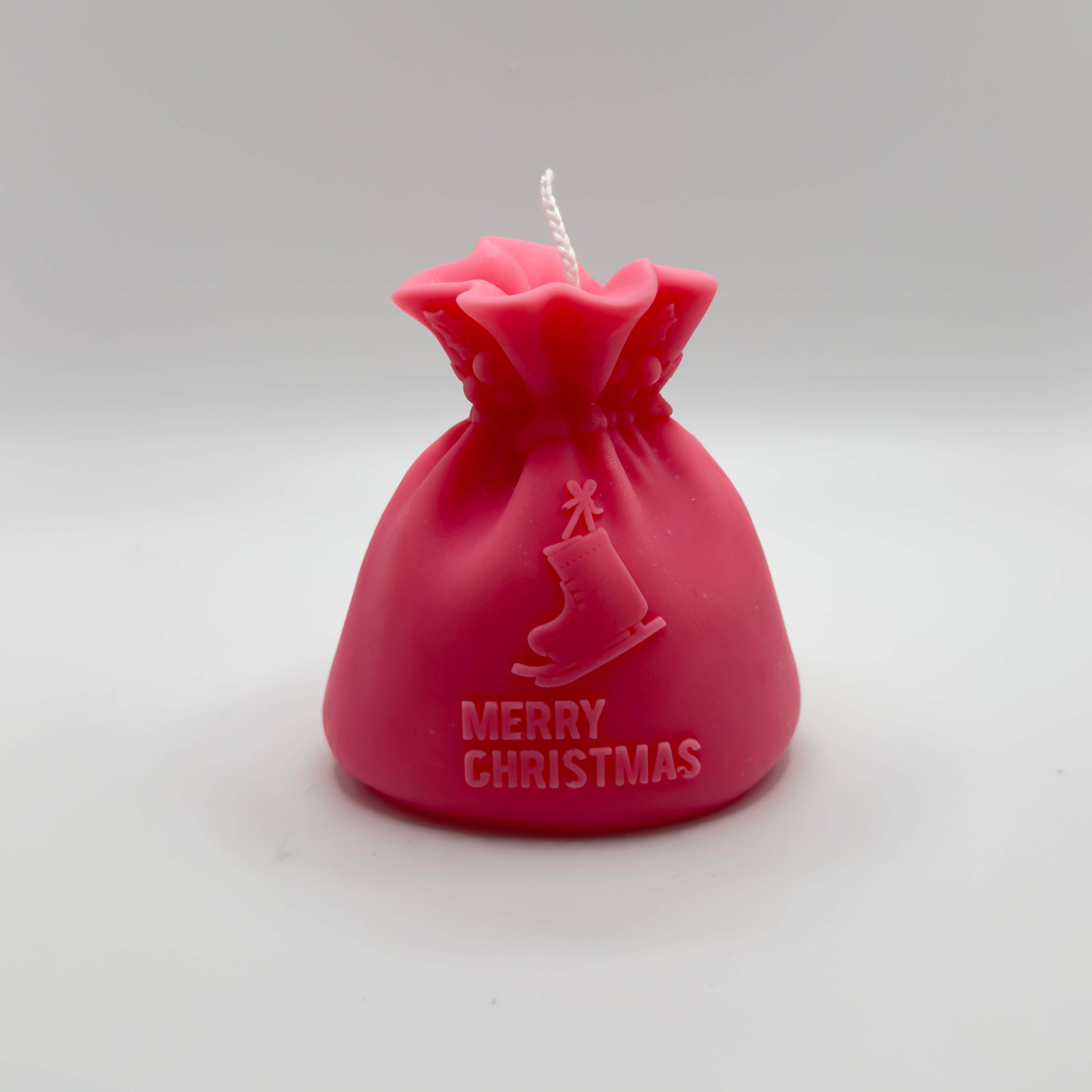 Handgefertigte pinke “Santa’s Gift Candle” aus Sojawachs, mit Schlittschuhmotiv und “Merry Christmas”-Schriftzug. Perfekt für eine weihnachtliche Dekoration oder als Geschenk.