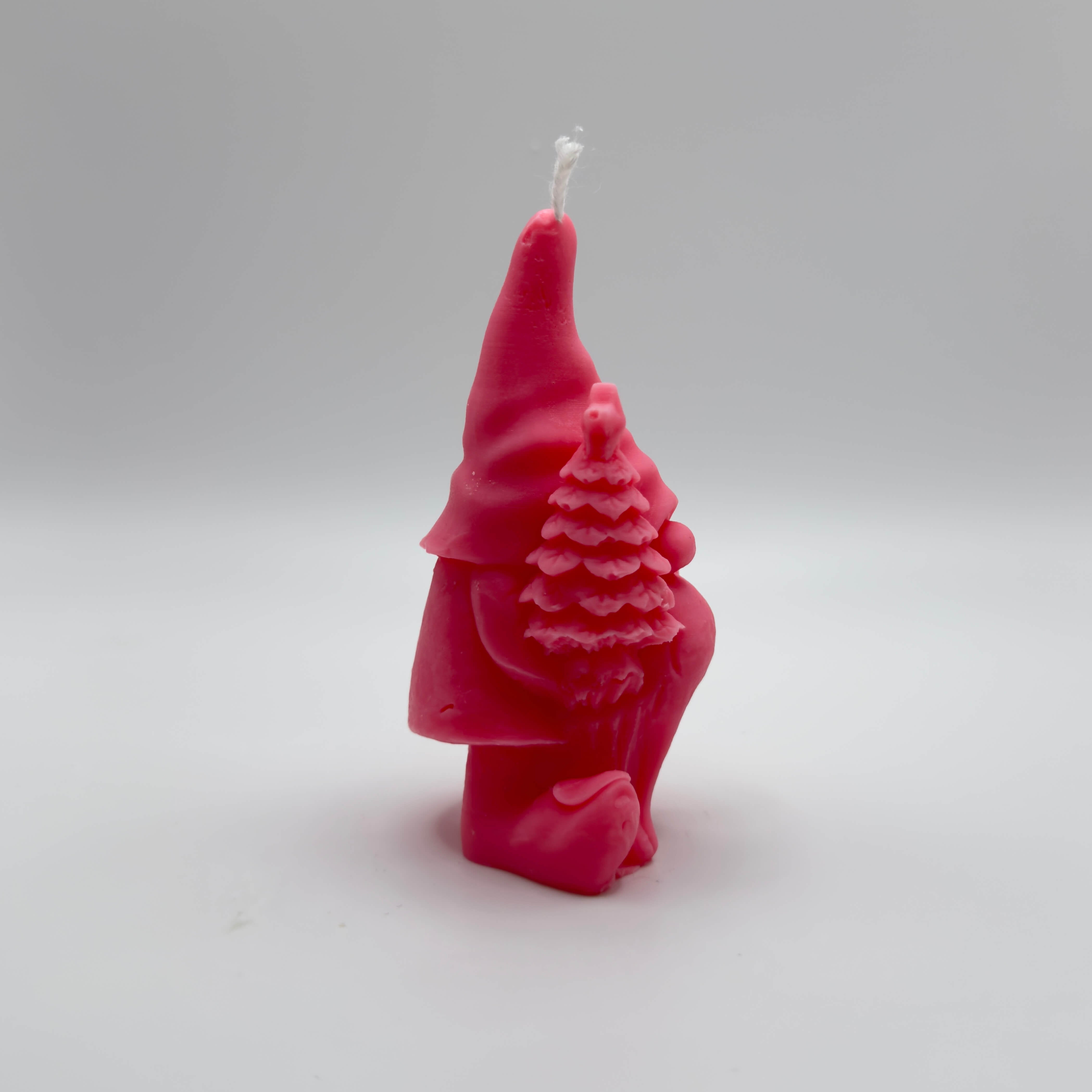 Festliche “Gnome’s Gift”-Kerze in knalligem Pink. Der Wichtel mit Geschenk und Baum zaubert weihnachtliche Stimmung.