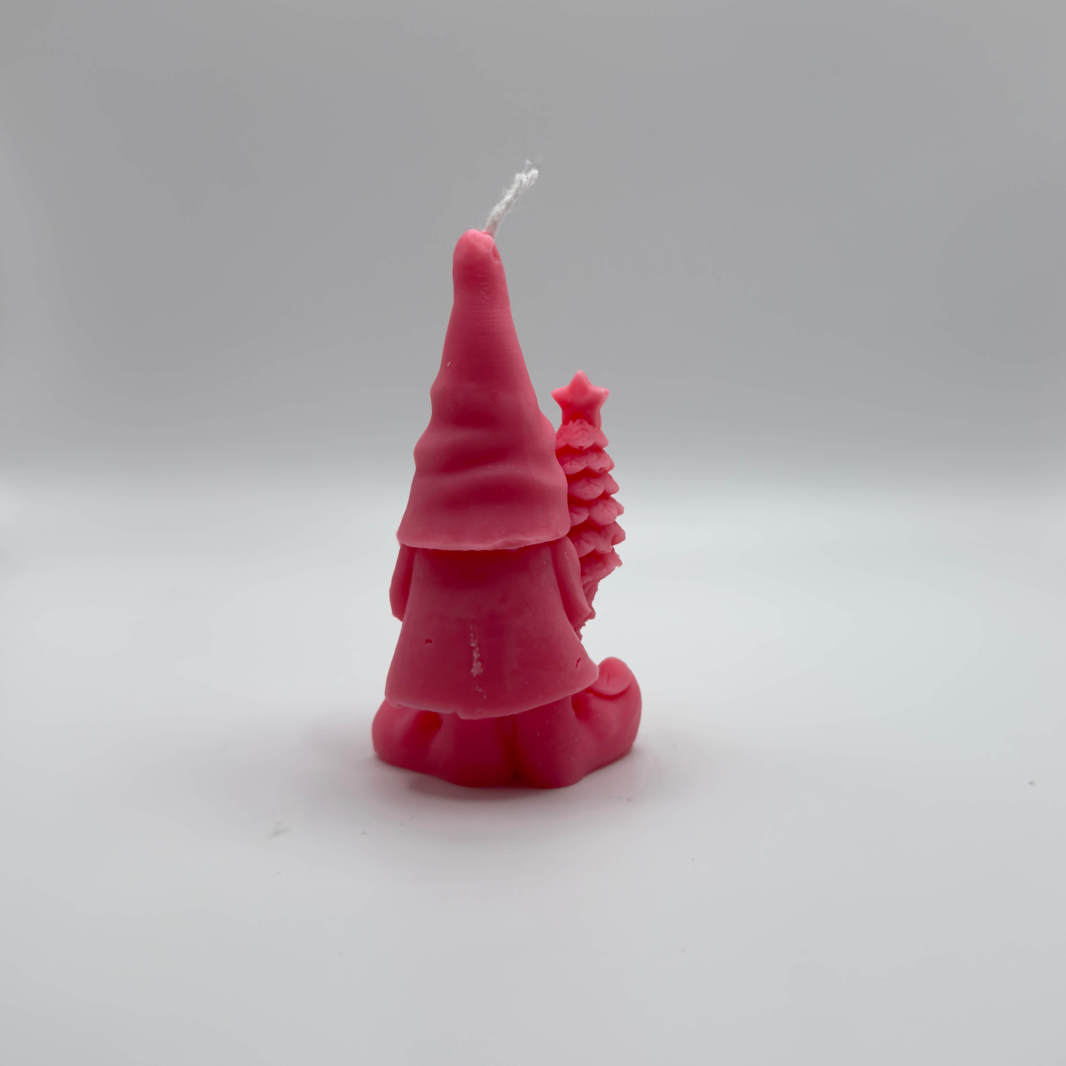 Festliche “Gnome’s Gift”-Kerze in zartem Pink. Der Wichtel mit Geschenk und Baum zaubert weihnachtliche Stimmung.