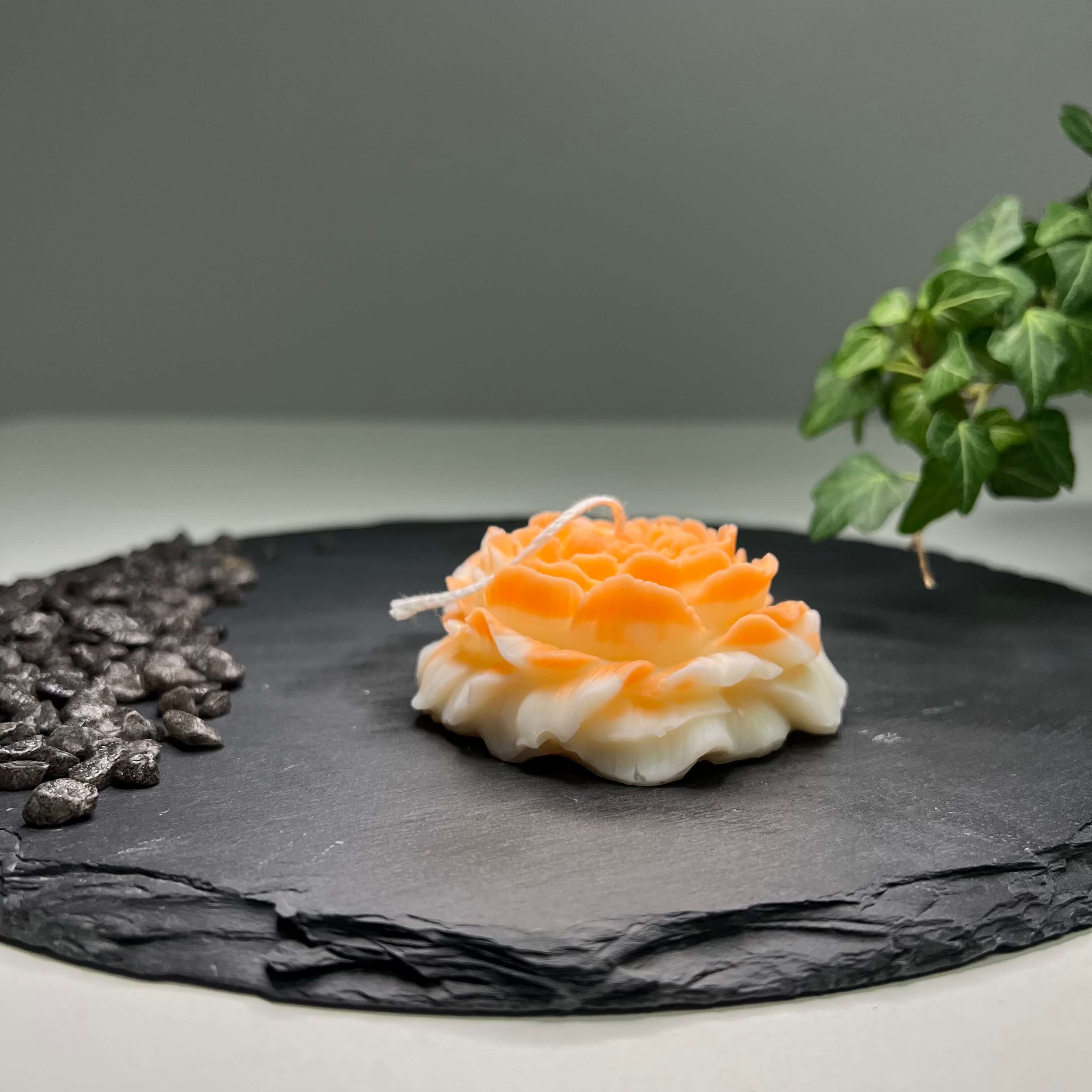 Auf diesem Bild sieht man die Rosé Petal Elegance Kerze. Sie ist handgemacht aus Bio Sojawachs. Zudem ist sie nachhaltig und vegan. In orange.