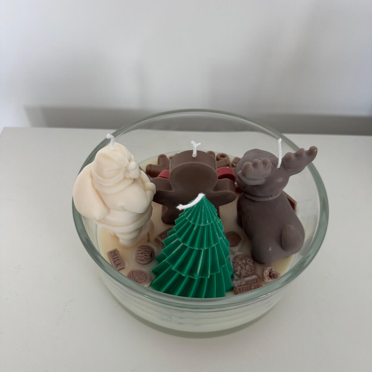 Detailansicht der handgefertigten Deko mit süßen Miniaturen, Schokolade und Candy-Elementen in der Kerze.