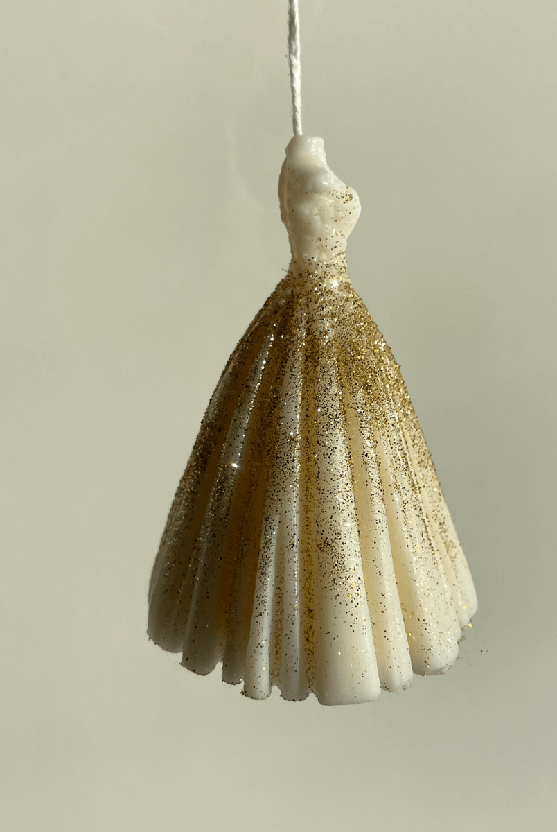 Unsere Hochzeitskleid Duftkerze Wedding Bliss Luminary. Sie ist in verschiedenen Düften erhältlich. Die Düfte haben einen angenehmen und beruhigenden Geruch. Sie ist perfekt für entspannte und gemütliche Tage. In weiß-gold.