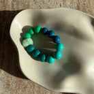 „Nahaufnahme des Aqua Breeze Armbands in einer Schale mit flauschigem Pom-Pom.“