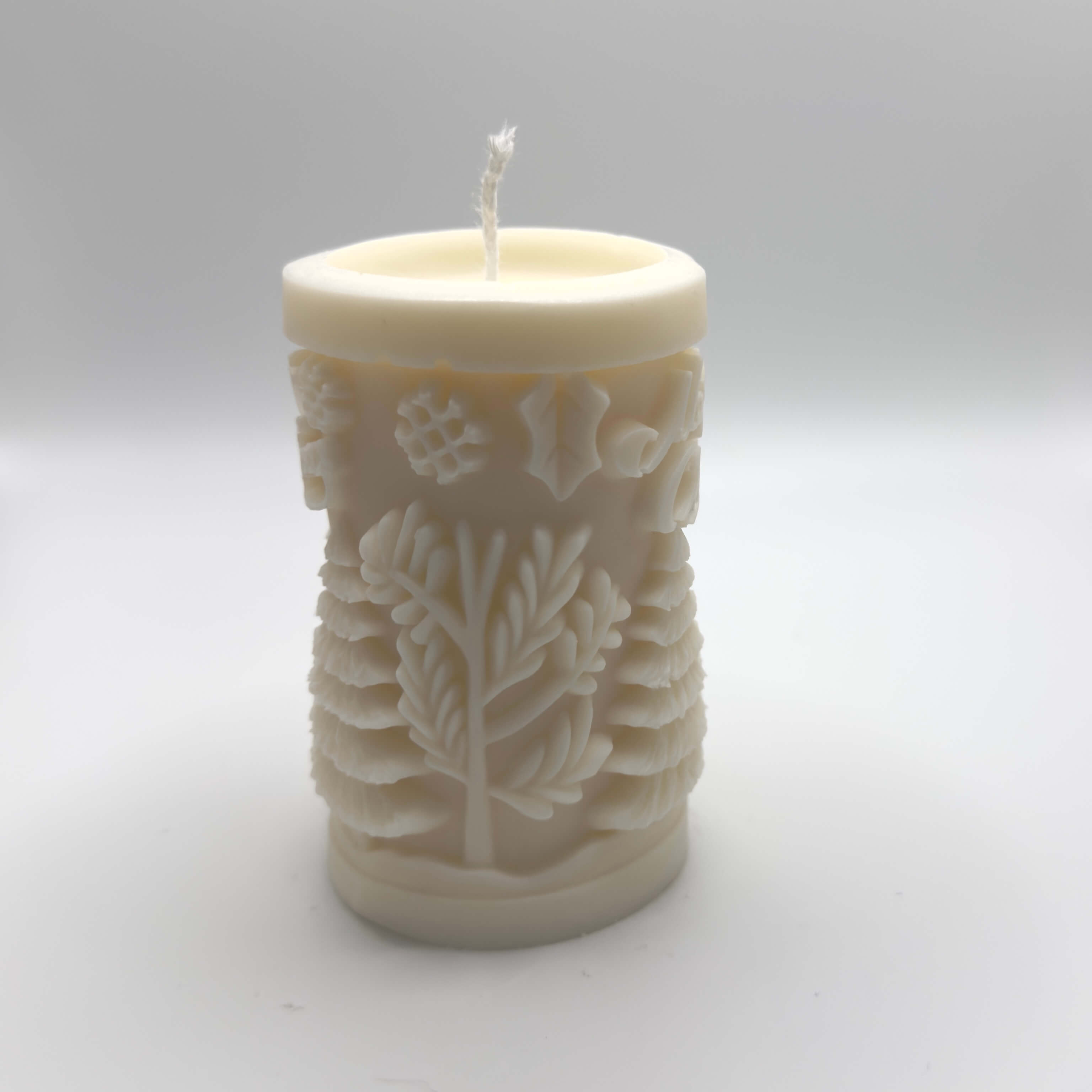 Evergreen Cheer Sojawachs-Kerze in Baumstammform mit “Merry Christmas”-Schriftzug, Tannen und Schneeflocken, ideal für Weihnachtsdekoration.