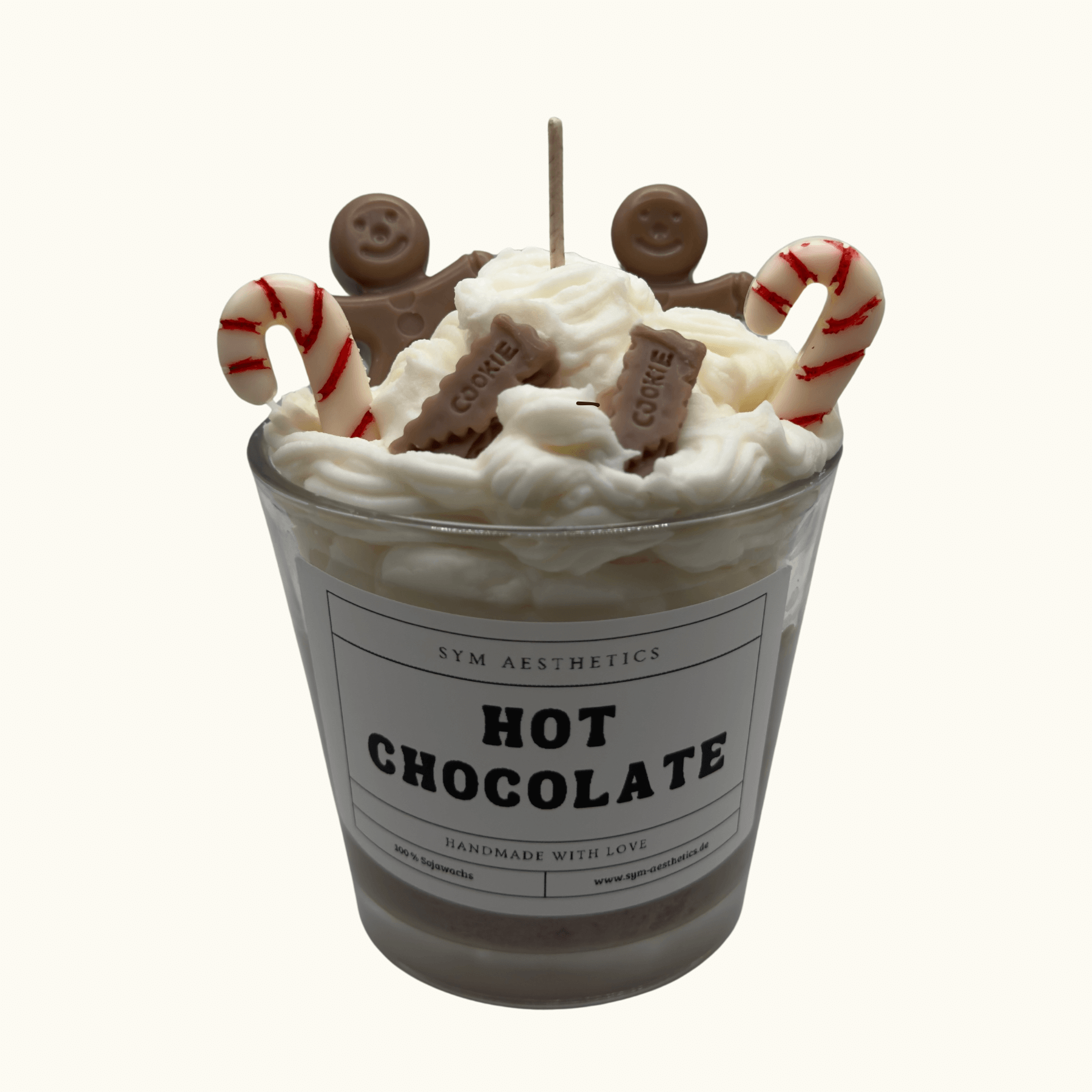 Hot Chocolate Candle in Tassenform mit Zuckerstangen, Lebkuchenmännern und Sahne – festliche Weihnachtsdekoration.