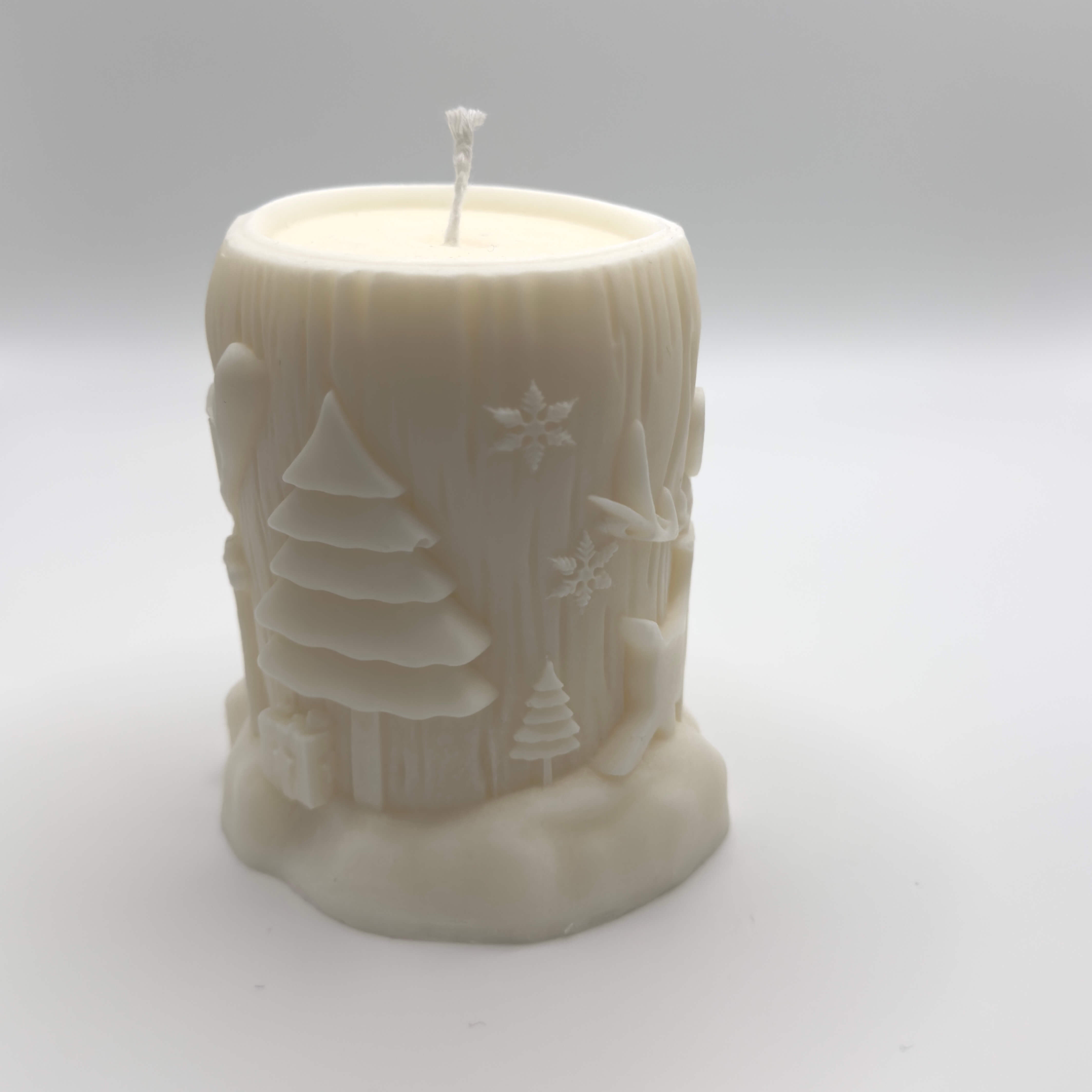 Winter Woodland Sojawachs-Kerze, Baumstammform mit Hirsch und weihnachtlichen Motiven wie Bäumen, Herzen und Schneeflocken für eine festliche Atmosphäre.