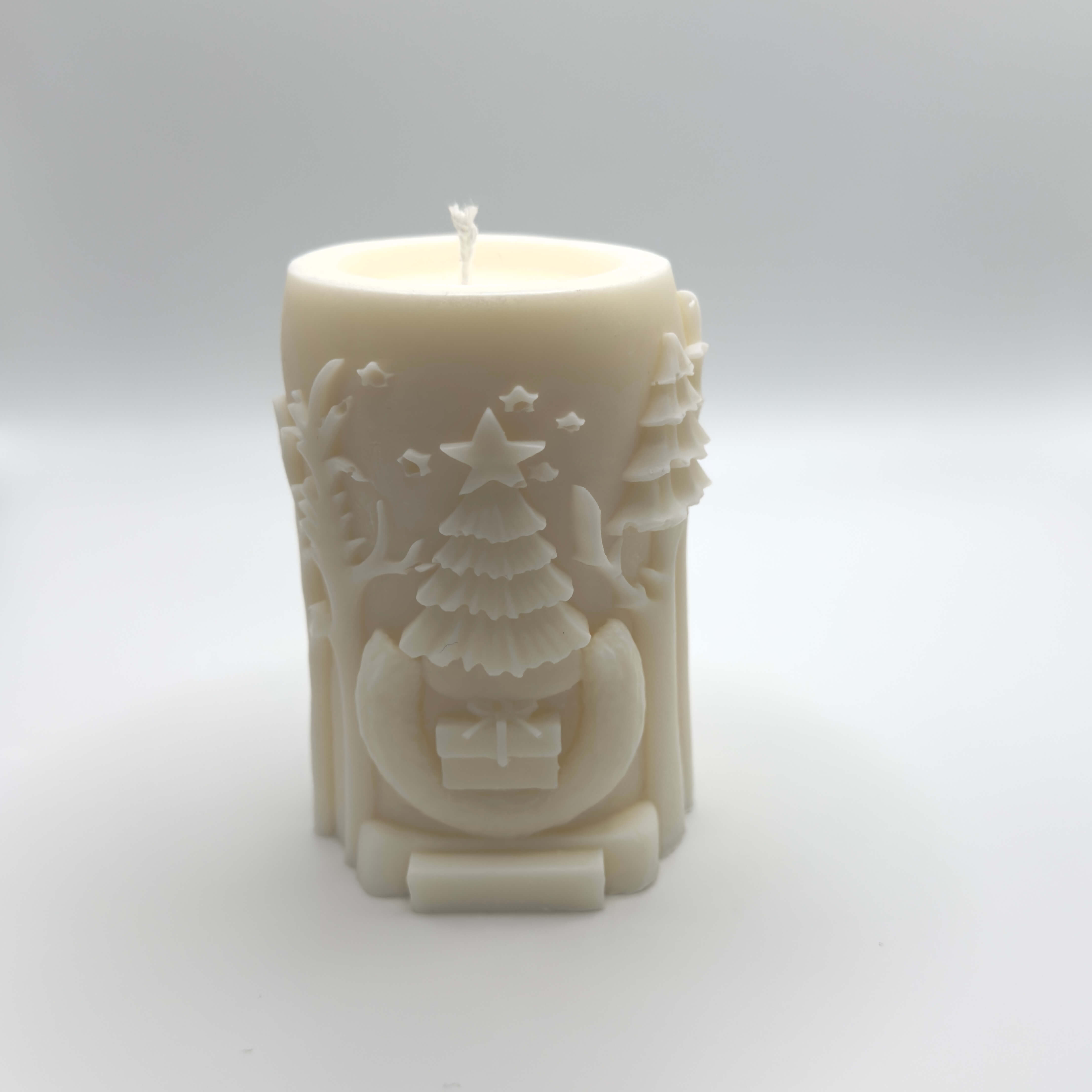 Woodland Majesty Sojawachs-Kerze, kunstvoll in Baumstammform, mit Hirsch und weihnachtlichen Geschenken, Bäumen und Sternen.