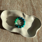 „Aqua Breeze Armband komplett in einer cremefarbenen Schale präsentiert.“