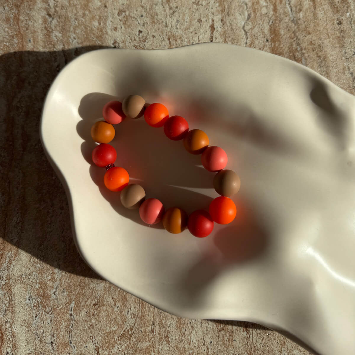 Nahaufnahme des Autumn Harvest Armbands in einer dekorativen Schale.