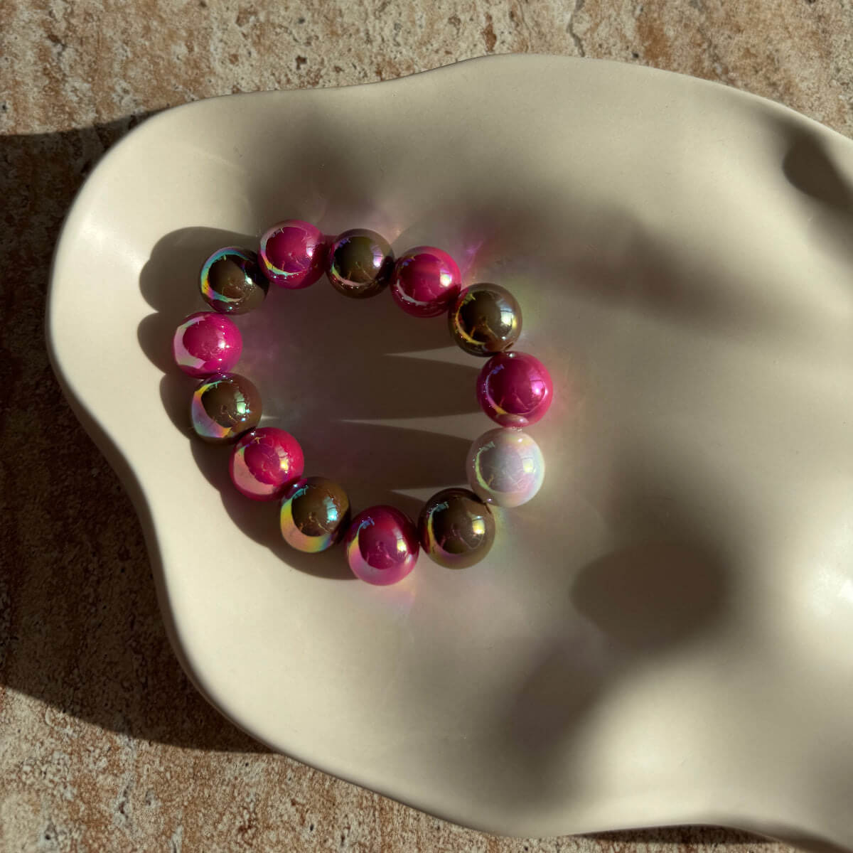 Nahaufnahme des Berry Mocha Glow Perlenarmbands in der Schale