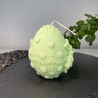 Hier sieht man unsere Bunny Celebration Egg Kerze. Mit ihrem Osterei und Hasen Design ist sie perfekt als Dekoration geeignet. Sie ist ästhetisch, stilvoll und elegant. In hellgrün.