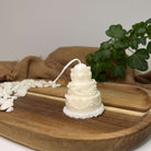 Hier sieht man unsere Celestial Wedding Cake Kerze, die aussieht wie eine Hochzeitstorte. Sie ist perfekt als Dekoration geeignet mit ihrem eleganten und ästhetischen Aussehen. Handgefertigt aus hochwertigem Sojawachs.