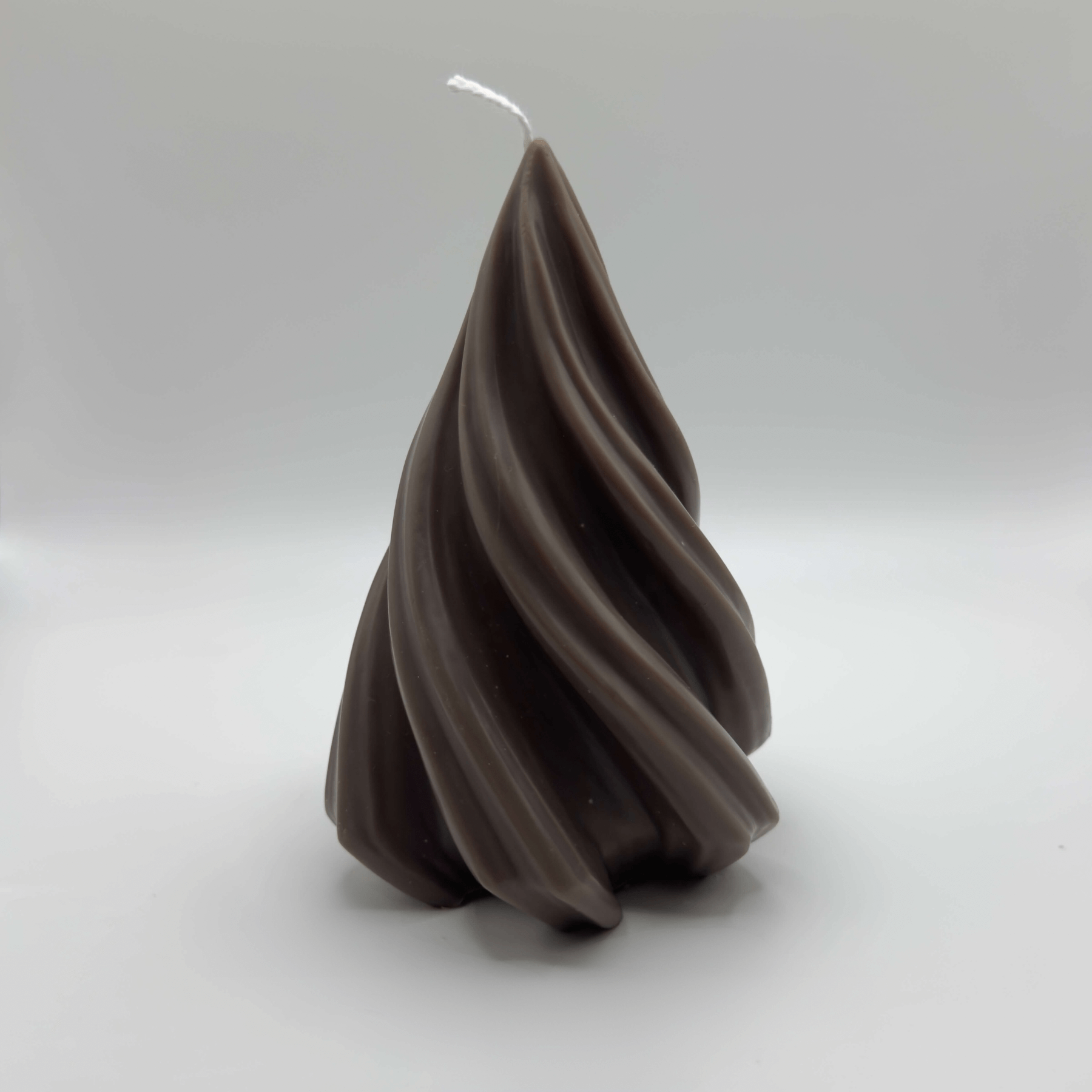 Die handgefertigte “Spiral Pine Tree” Kerze in Dunkelbraun verbindet moderne Eleganz mit klassischer Weihnachtsbaumform und nachhaltigem Sojawachs.