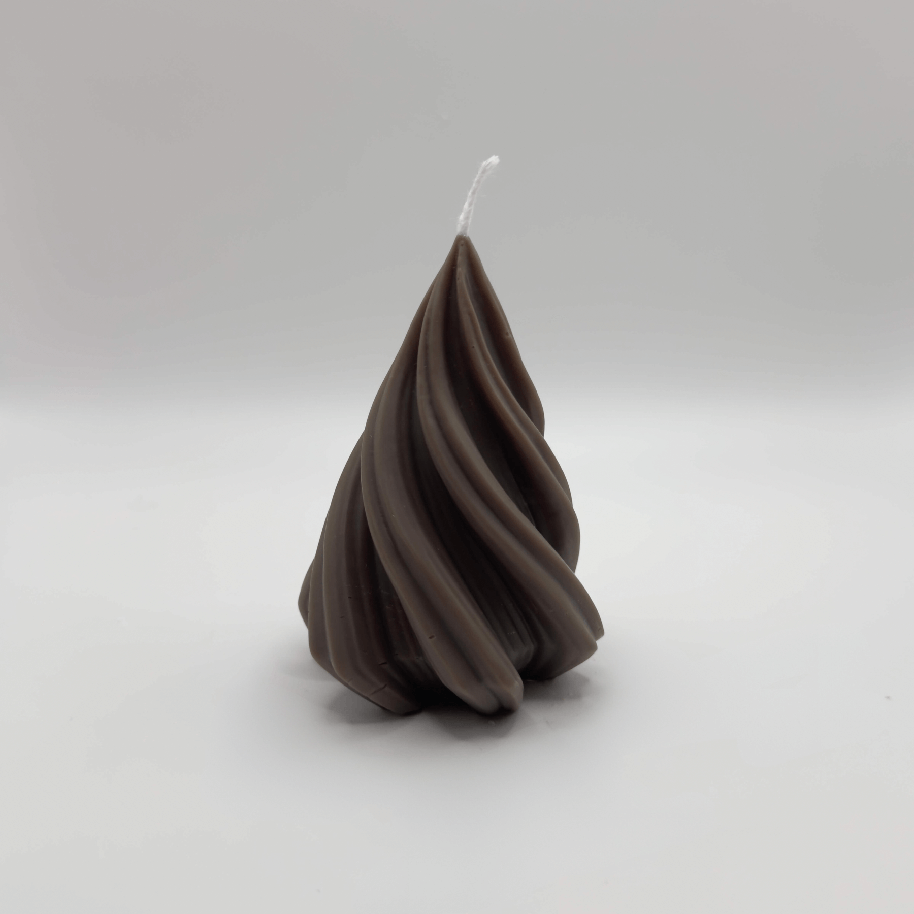 Die dunkelbraune “Spiral Pine Tree” Kerze aus handgefertigtem Sojawachs besticht durch ihr modernes spiralförmiges Tannendesign und nachhaltige Eleganz.