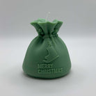Dunkelgrüne “Santa’s Gift Candle” aus handgefertigtem Sojawachs. Ein weihnachtliches Design mit Schlittschuh und “Merry Christmas”-Schriftzug.