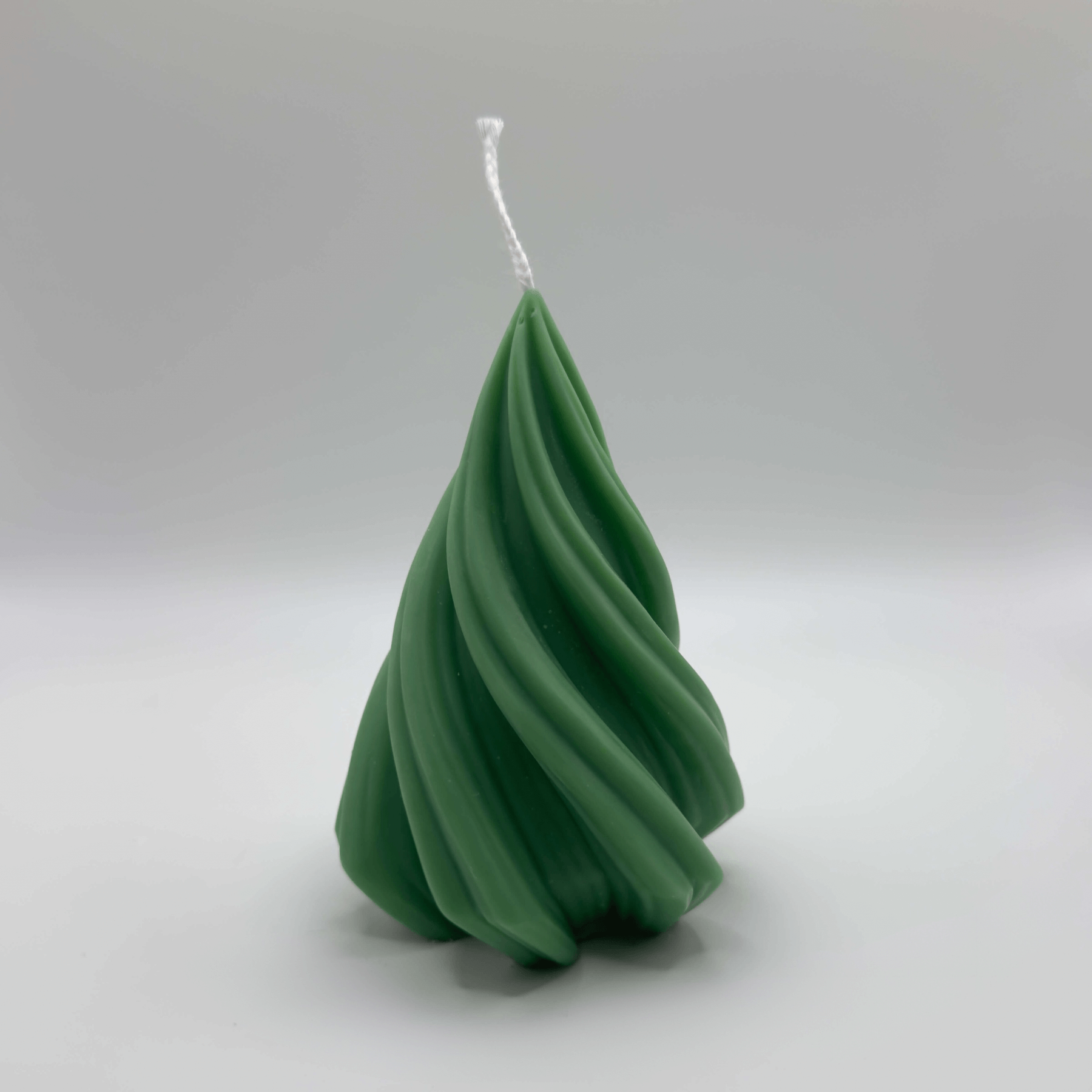 Die dunkelgrüne “Spiral Pine Tree” Kerze aus natürlichem Sojawachs besticht durch ihr spiralförmiges Tannendesign und ihre nachhaltige Herstellung.