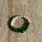 Armband Emerald Pearl Harmony auf hellem Untergrund, aufgenommen auf einem Tisch bei natürlichem Licht.