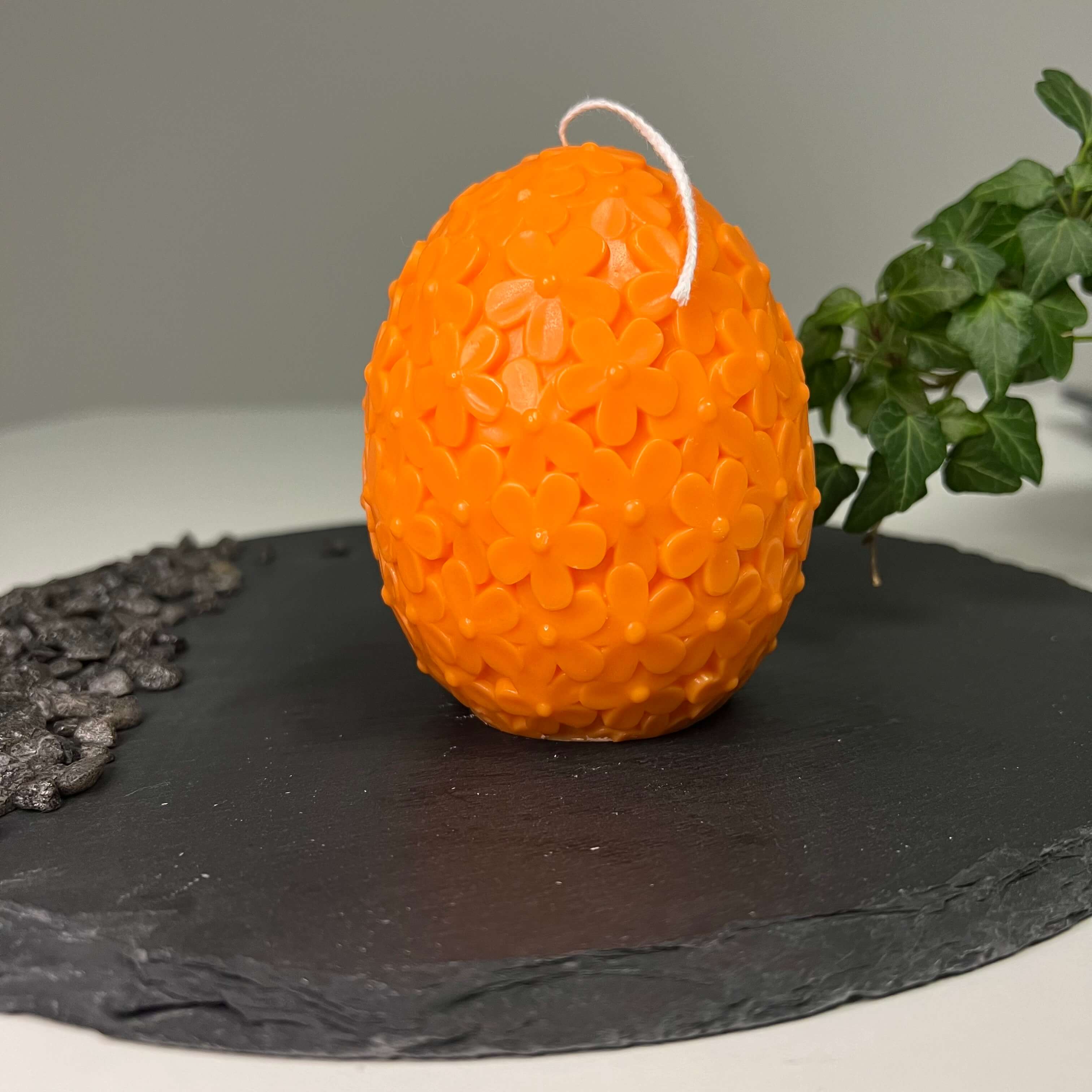 Auf diesem Bild sieht man unsere Floral Easter Egg Brilliance Kerze. Sie ist handgemacht aus Sojawachs. Sie ist nachhaltig, vegan und umweltfreundlich. In orange.