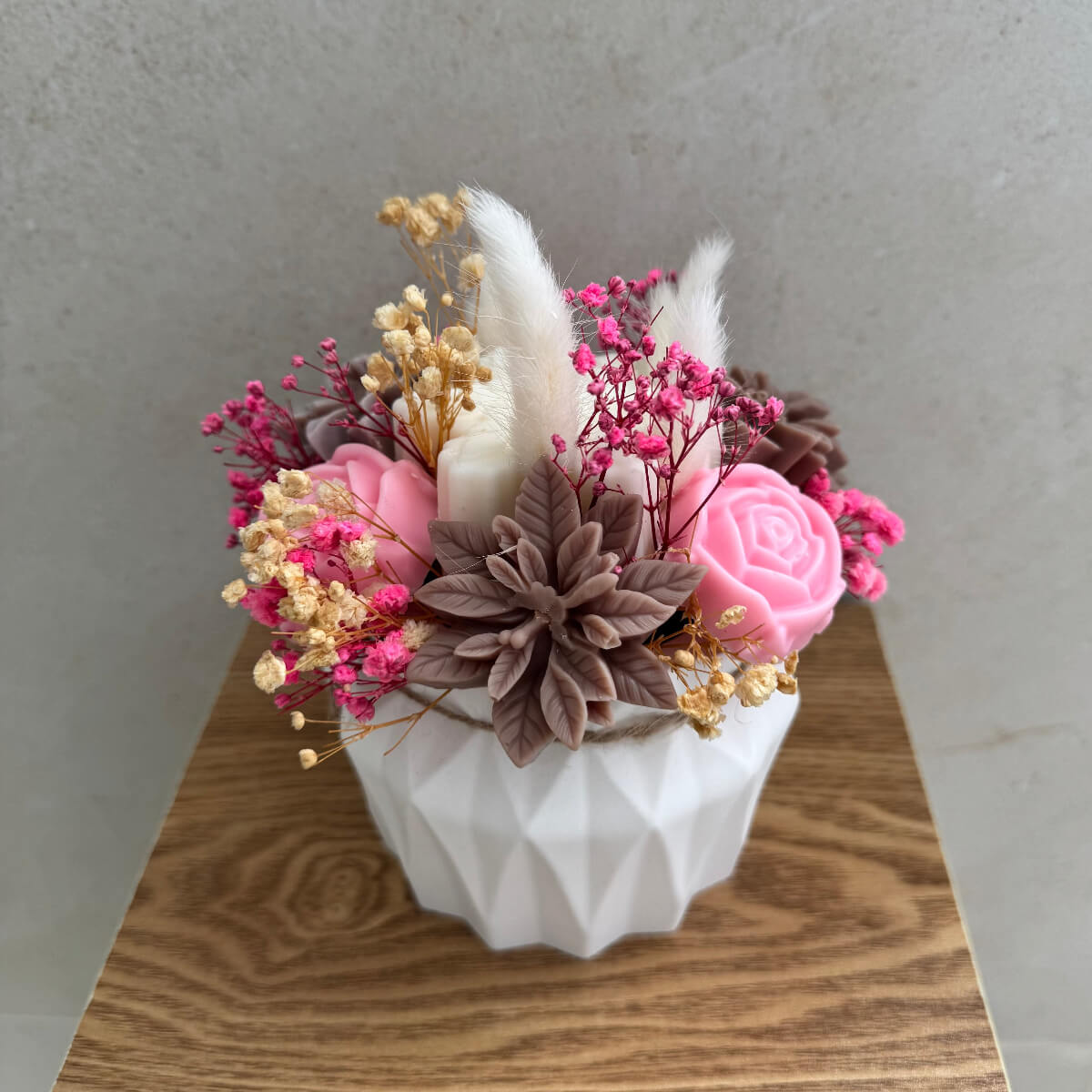 Weiße Schneeflocke aus Sojawachs in der Mitte des Arrangements.