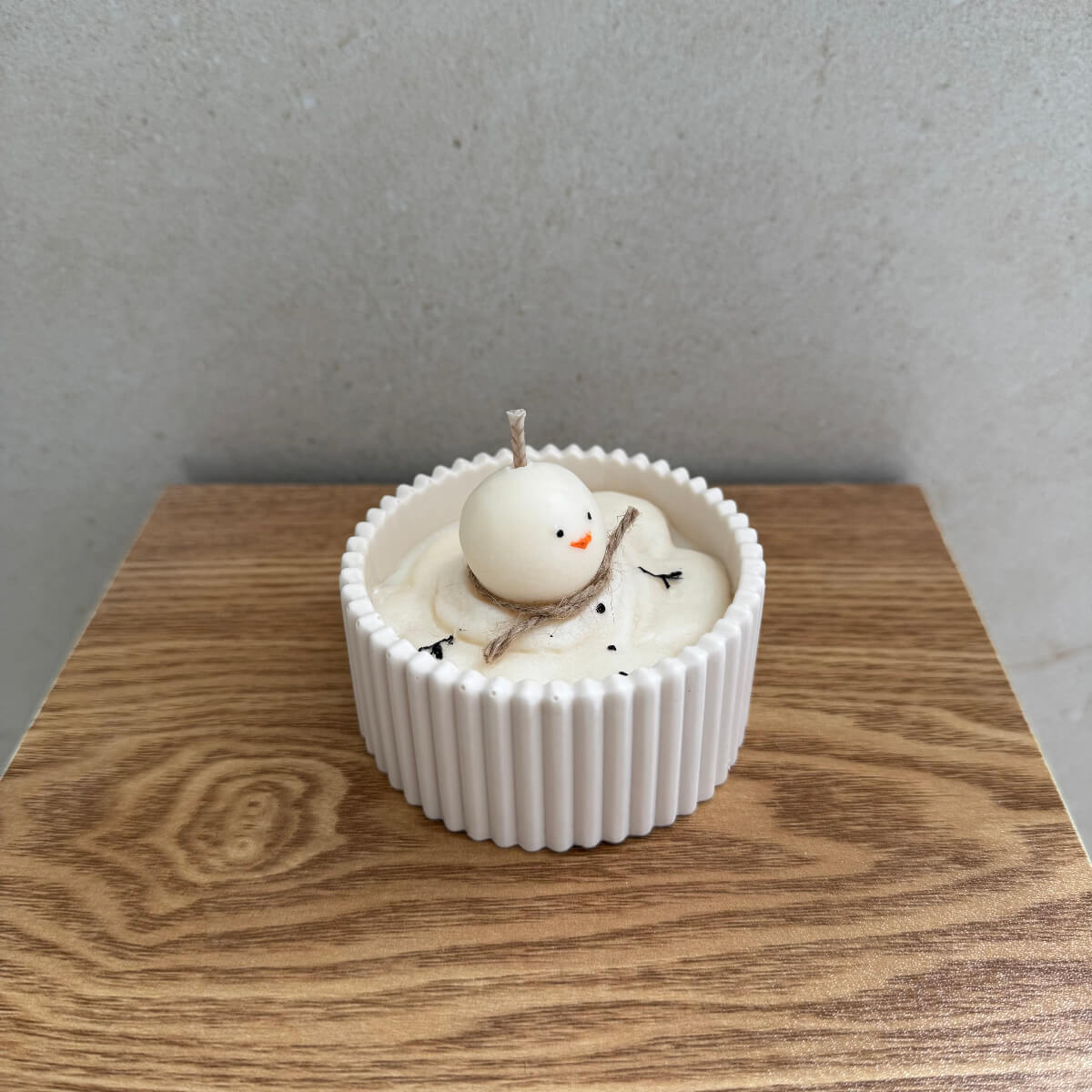 Handgemachte Schneemann-Kerze Frosty’s Melt Moment in weißer Keramikschale auf Holztisch