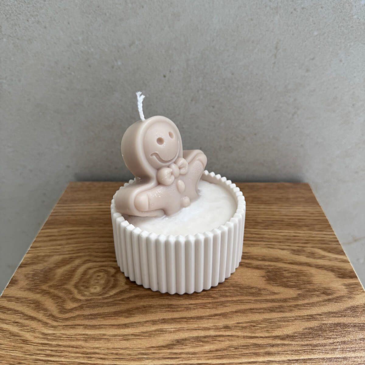 Detailaufnahme des kleinen Lebkuchenmanns aus Wachs, eingebettet in weißen Schneewachs und umgeben von süßen Miniatur-Elementen – liebevoll handgefertigt bei Sym Aesthetics.