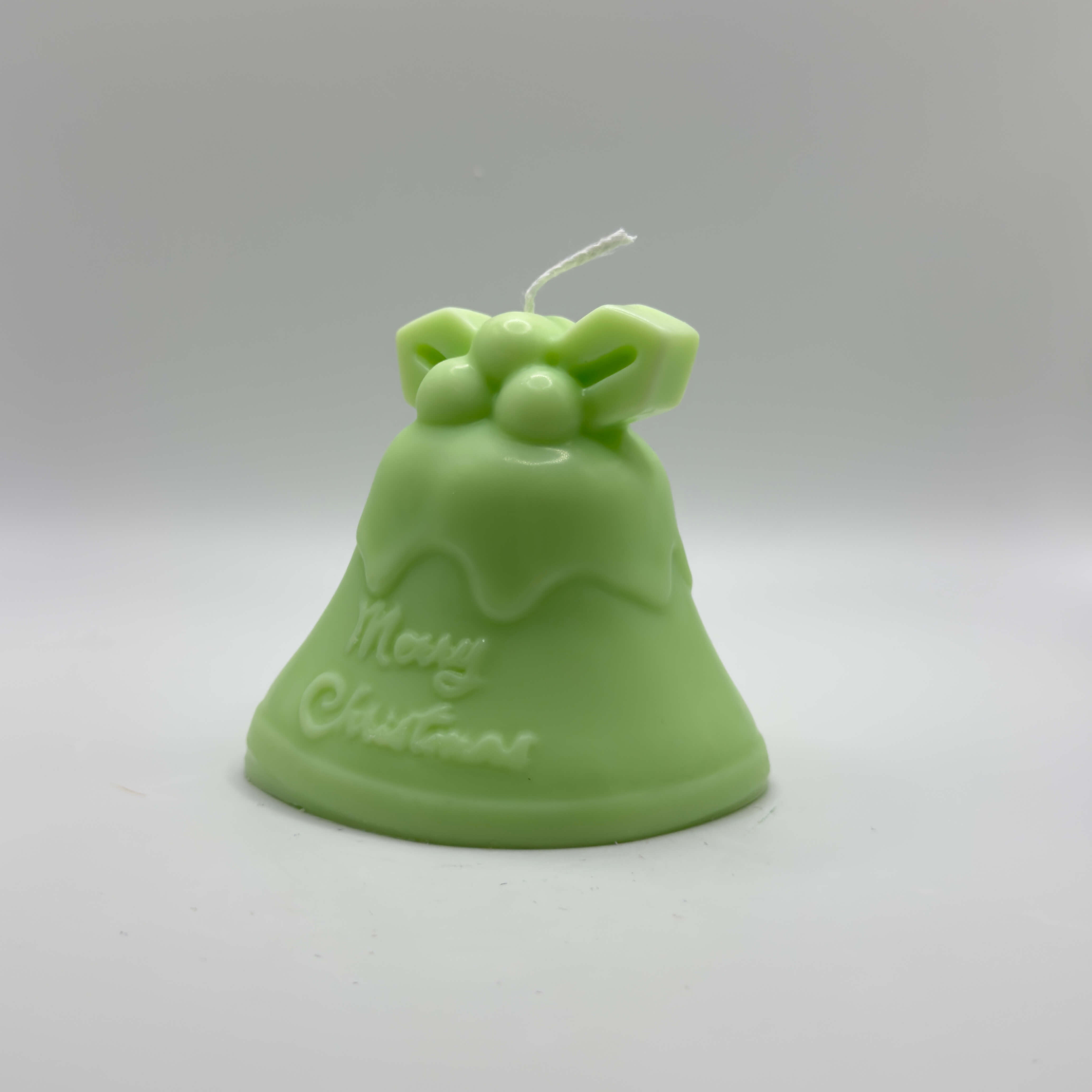 Sanfte hellgrüne „Mistletoe Bell“-Kerze aus Sojawachs mit Mistelzweig-Verzierung und „Merry Christmas“-Schriftzug. Bringt Leichtigkeit und Freude in jede Weihnachtsdekoration.