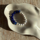 Nahaufnahme des Lunar Sapphire Armbands in einer Schale – detaillierte Ansicht der Perlen und des blauen Kristalls.