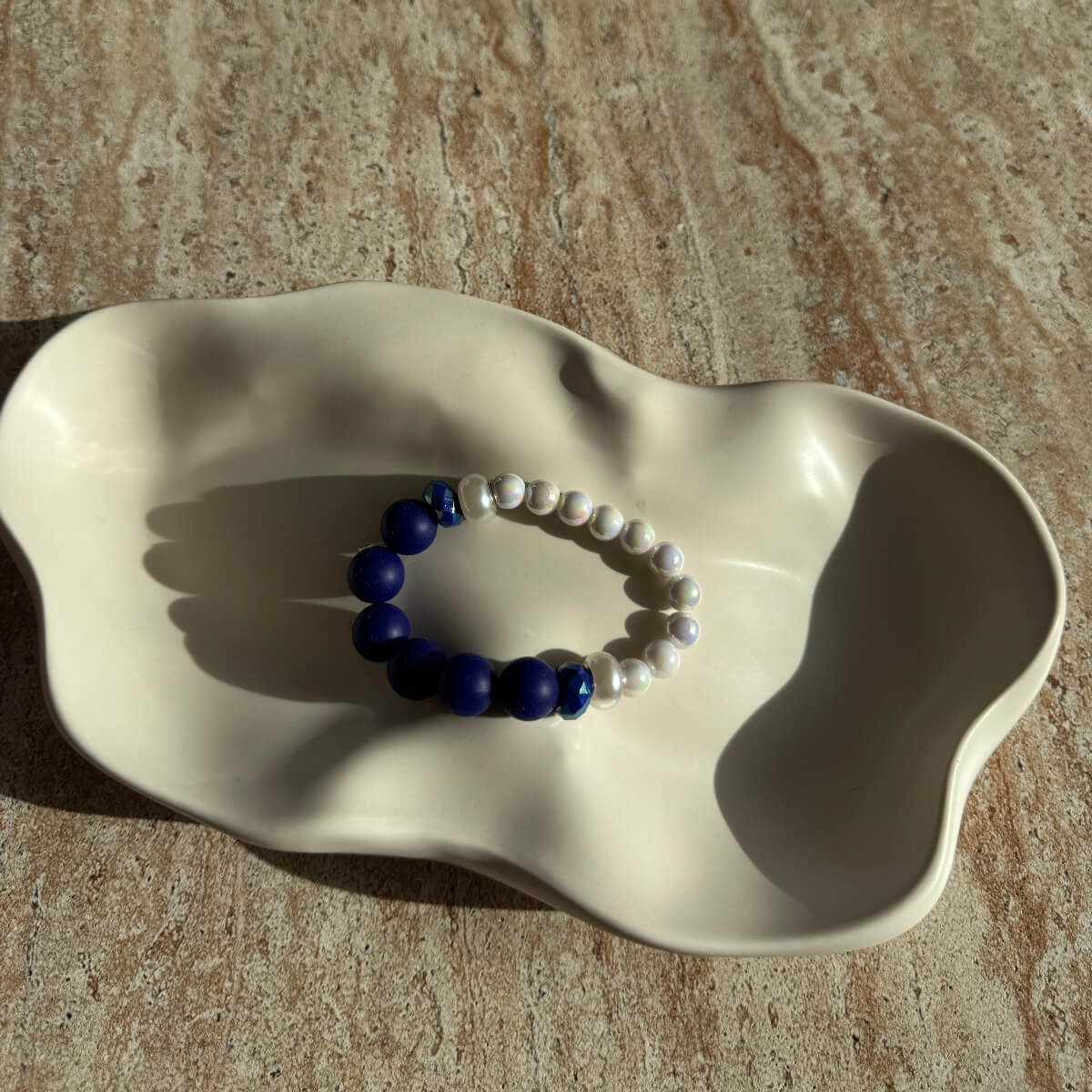 Komplettes Lunar Sapphire Armband in einer Schale, elegant arrangiert für Produktfotografie.