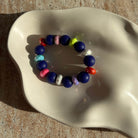 Nahaufnahme des Midnight Carnival Armbands in der Schale mit farbigen Akzentperlen.