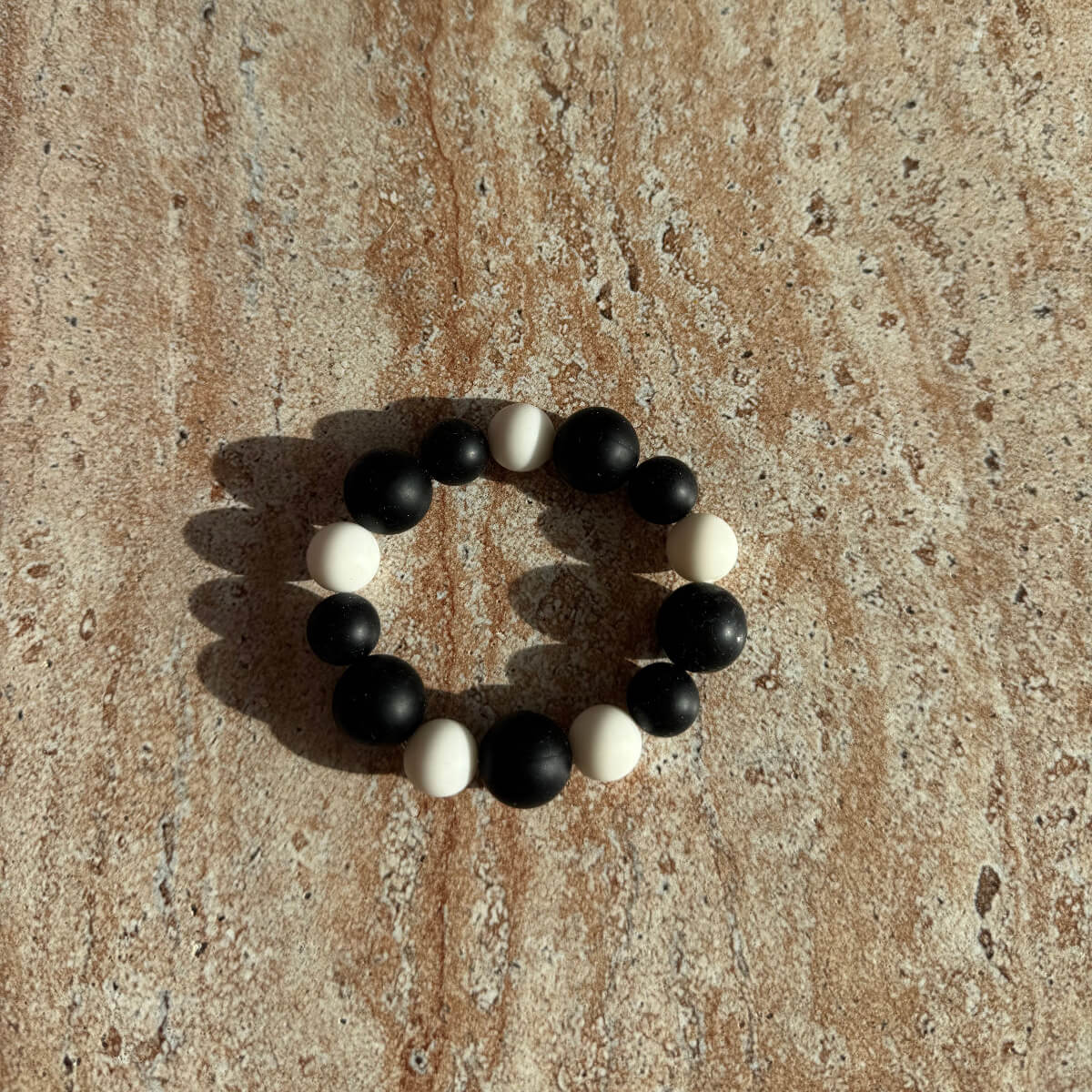 „Schwarz-weißes Armband Midnight Frost auf einem Tisch arrangiert.“